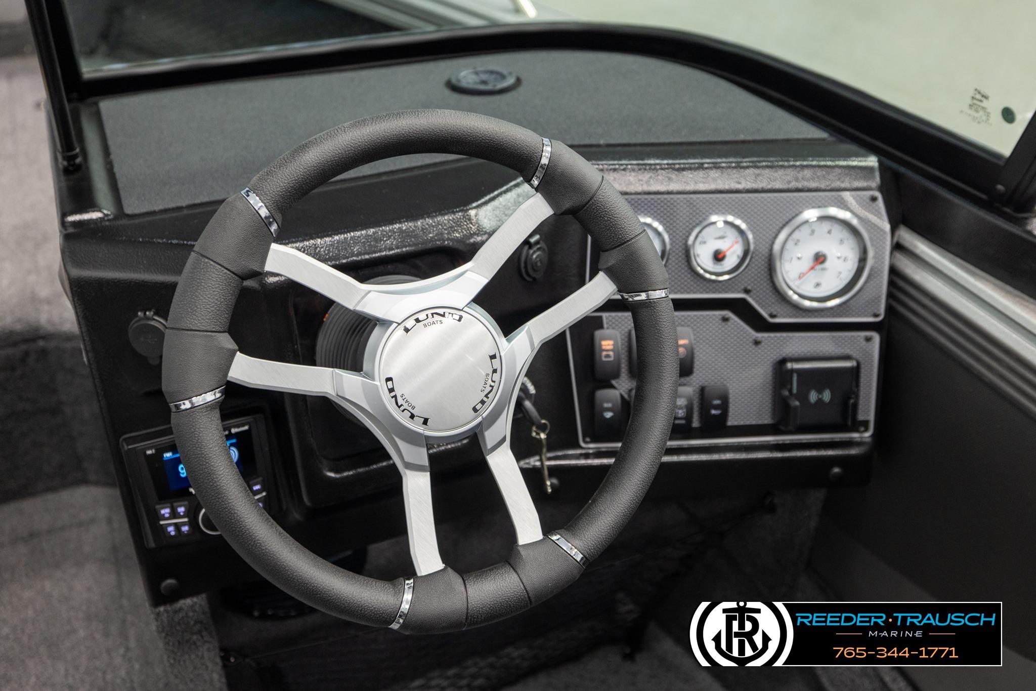 Steering wheel and dashboard of 2026 Lund 1975 Tyee boat, featuring modern controls.