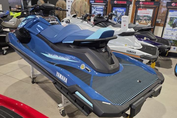 2026 Yamaha WaveRunner VX Cruiser in showroom, blue and black design, displayed among other models.