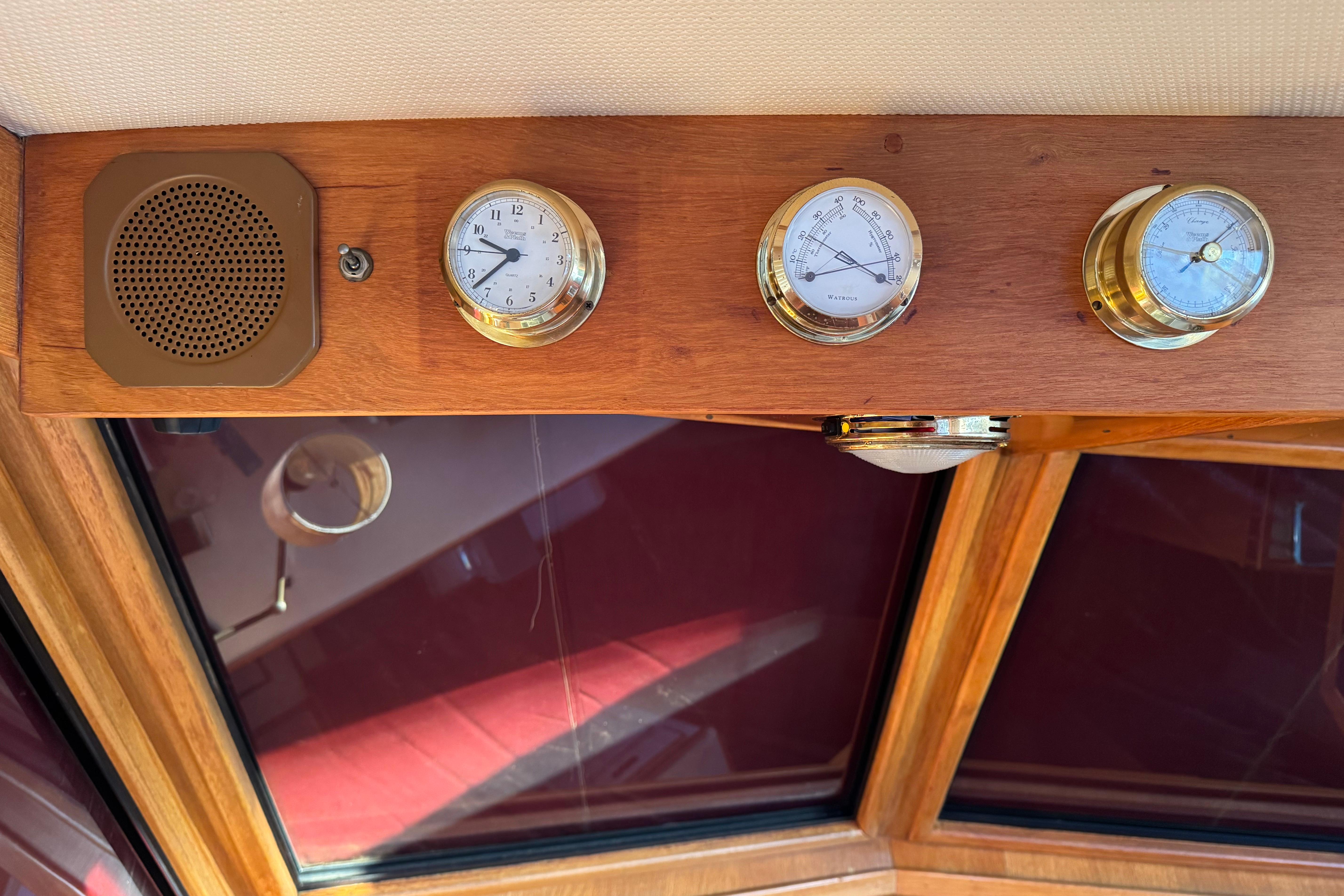 Wooden dashboard with brass instruments and speaker on a 1987 President 37 yacht.