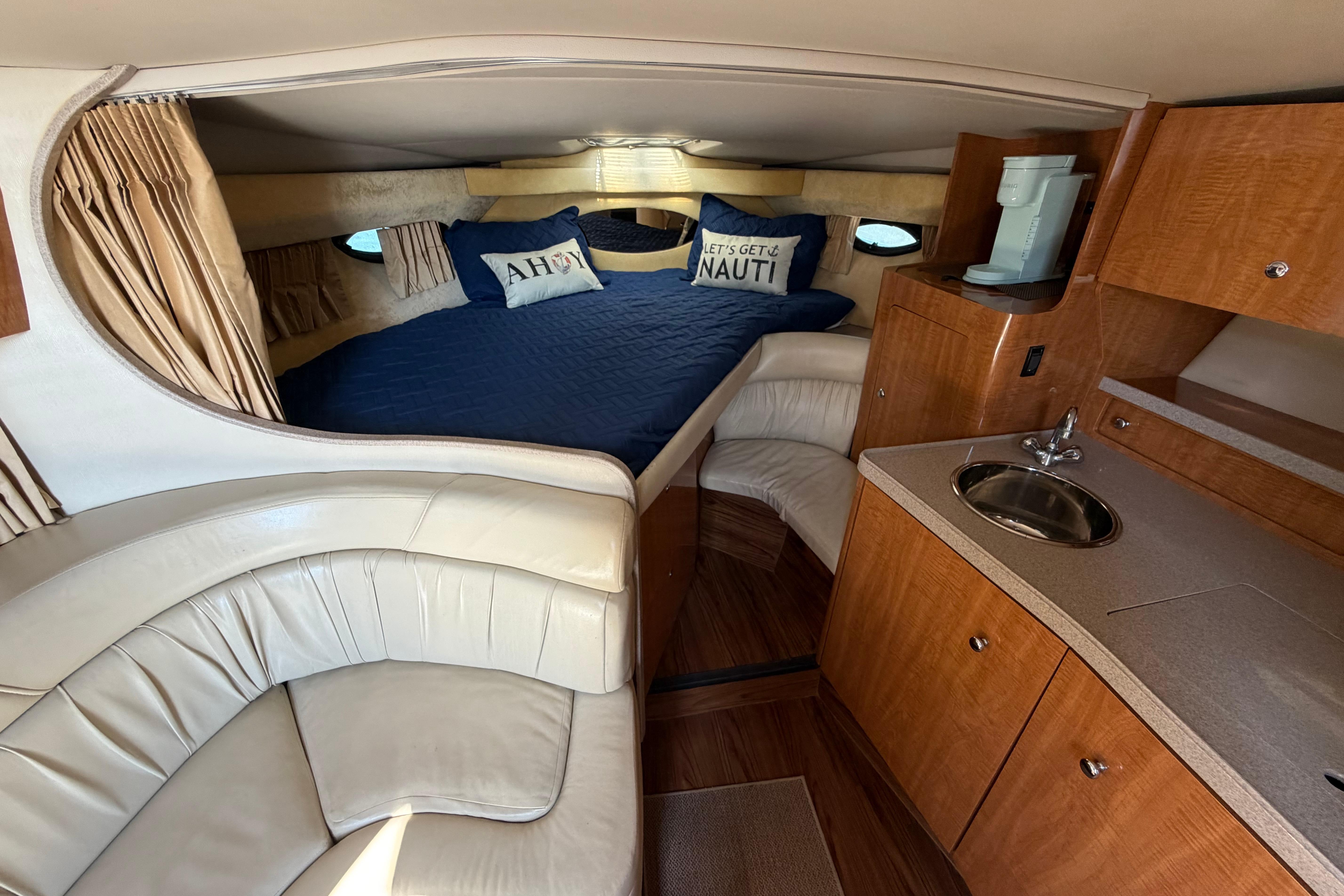 Interior of 2003 Regal Commodore 3260 yacht with cozy bed and kitchenette.