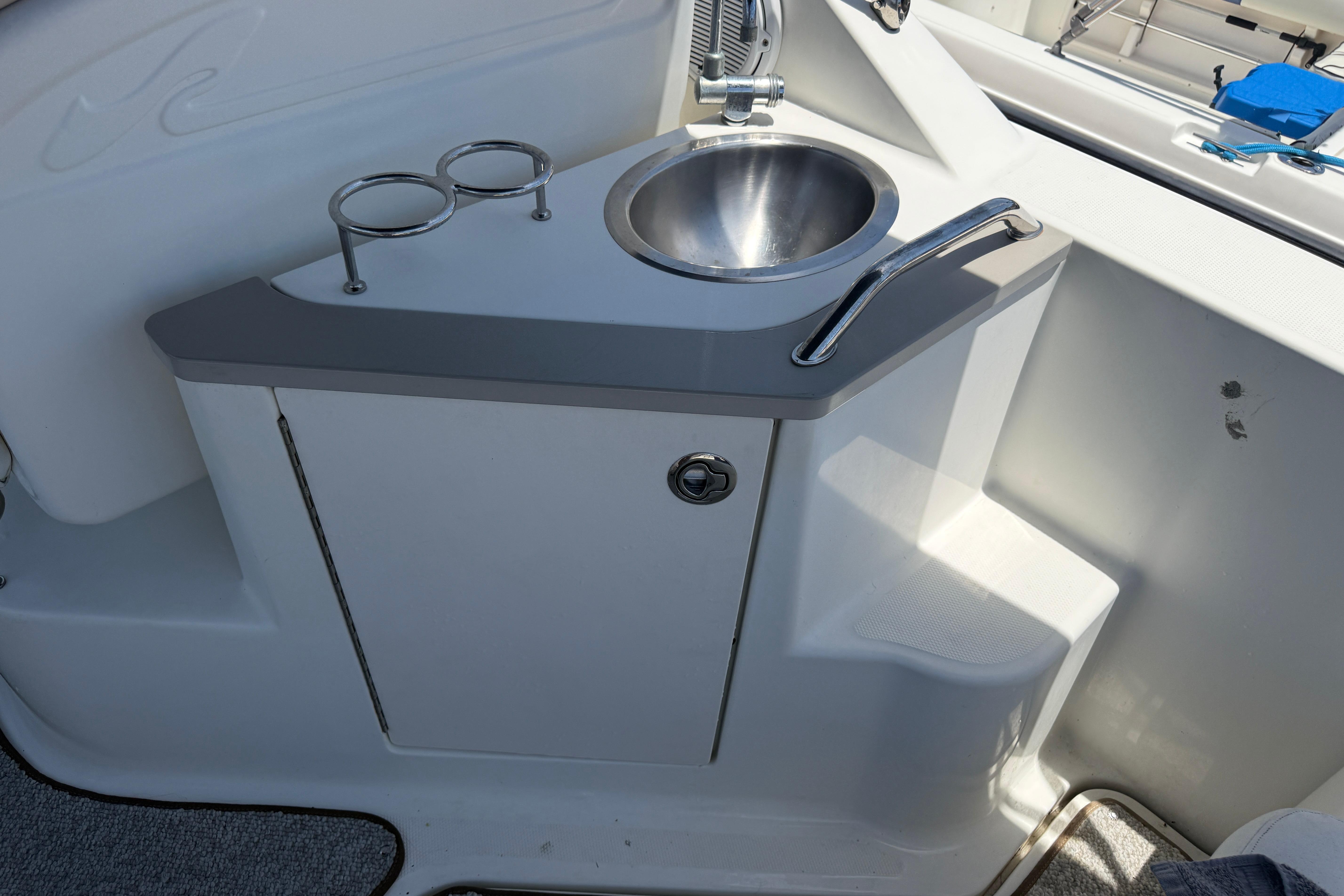 2009 Sea Ray 240 Sundancer boat sink with faucet and cup holders.