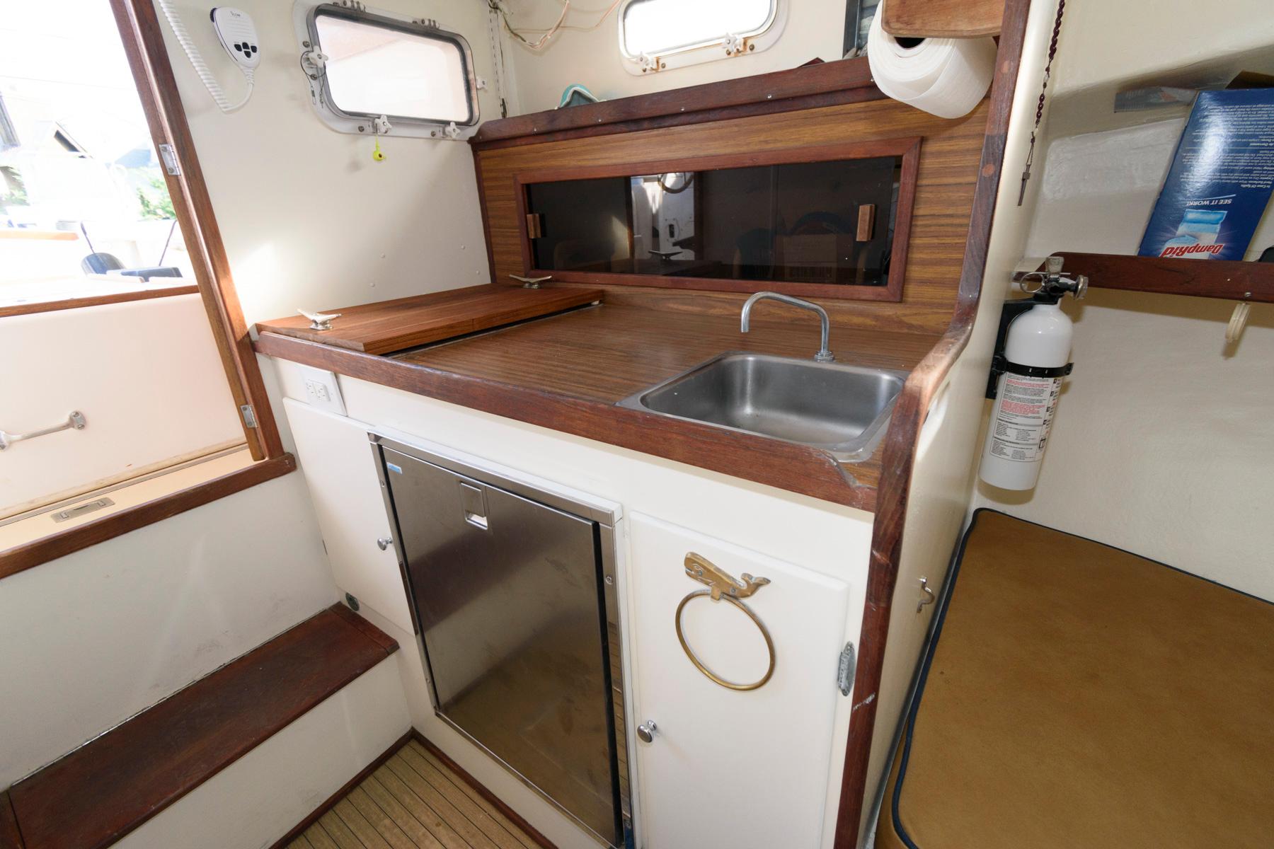 1983 Dyer 29 Downeast Express boat interior with compact kitchen and sink.