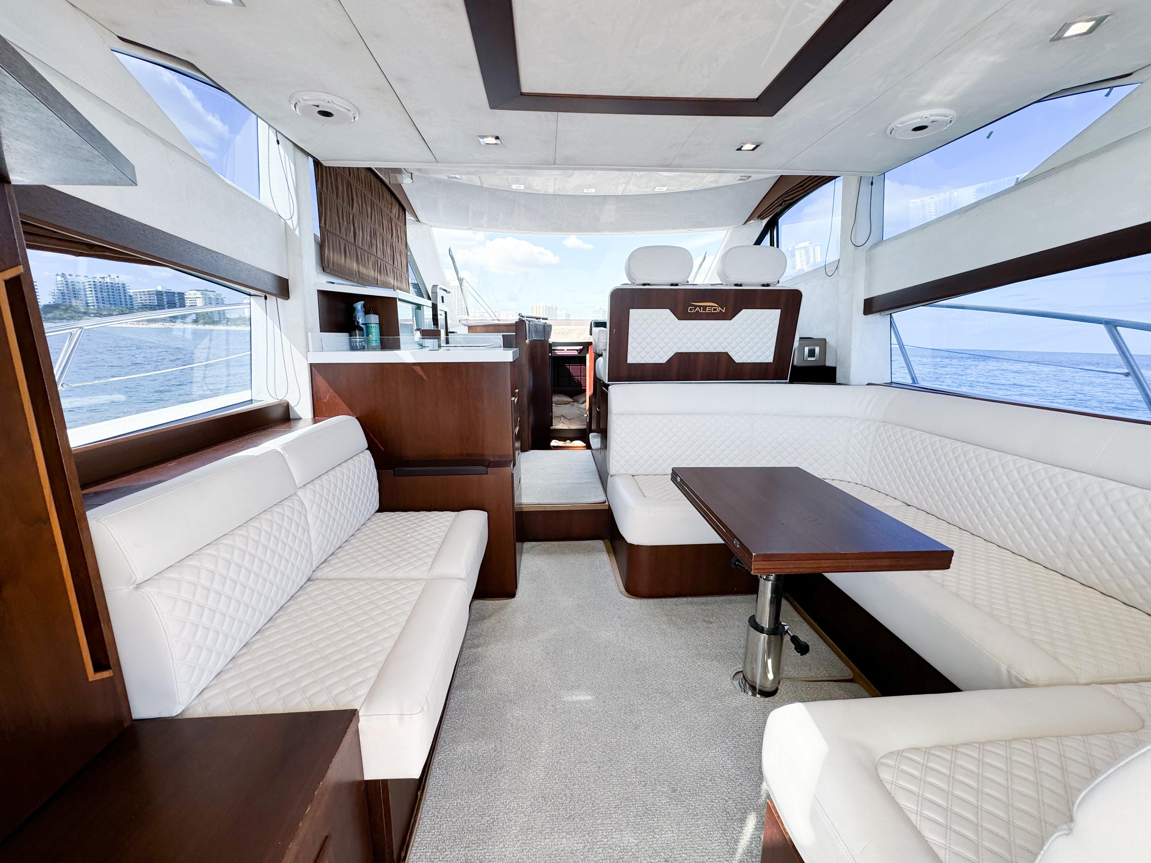 Luxurious interior of 2016 Galeon 420 Fly yacht with elegant seating and panoramic windows.