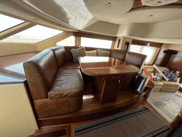 Luxurious interior of a 2009 Ovation 52 yacht with leather seating and wooden table.