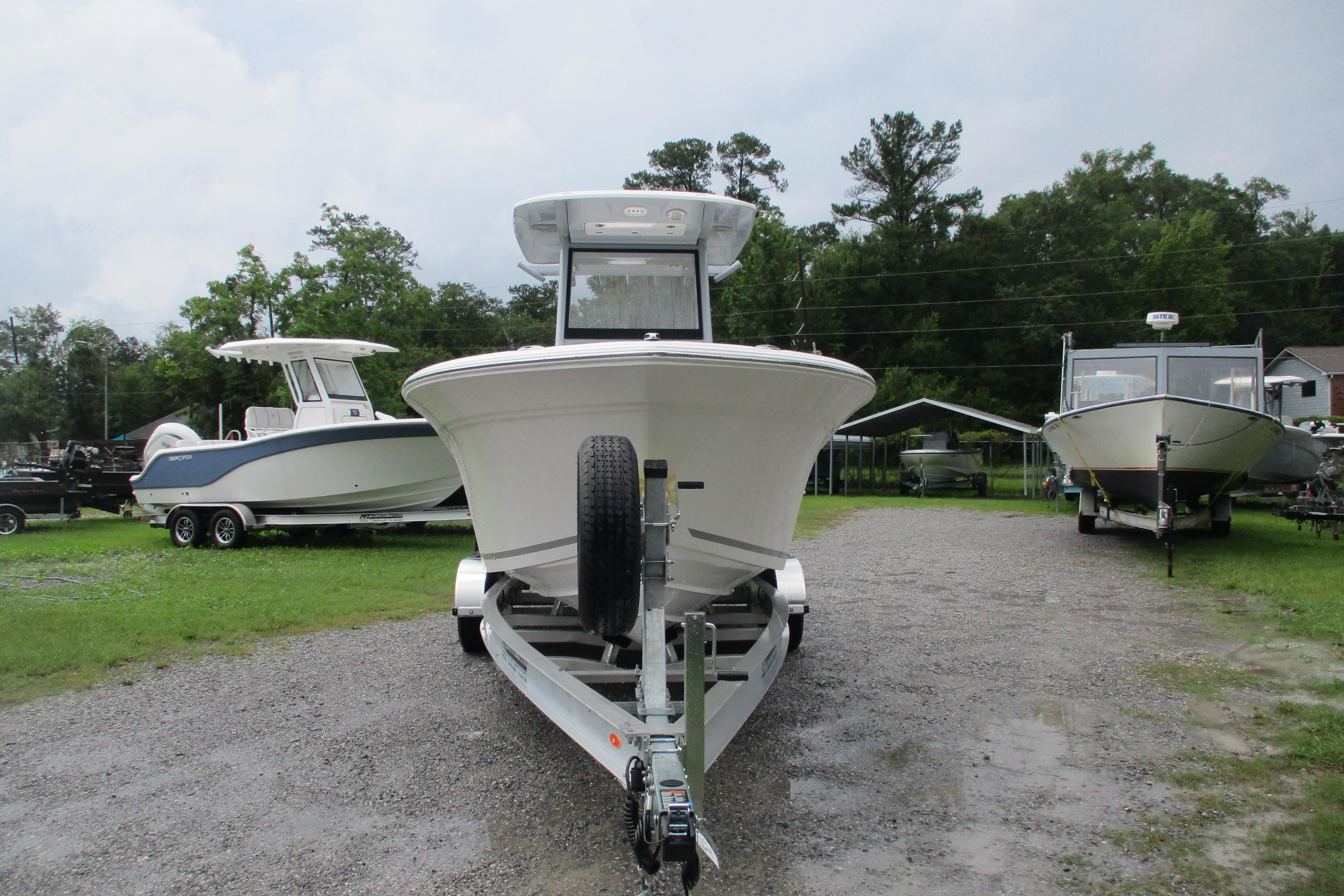 2026 Sea Fox 248 Commander boat on trailer, parked outdoors with trees in background.