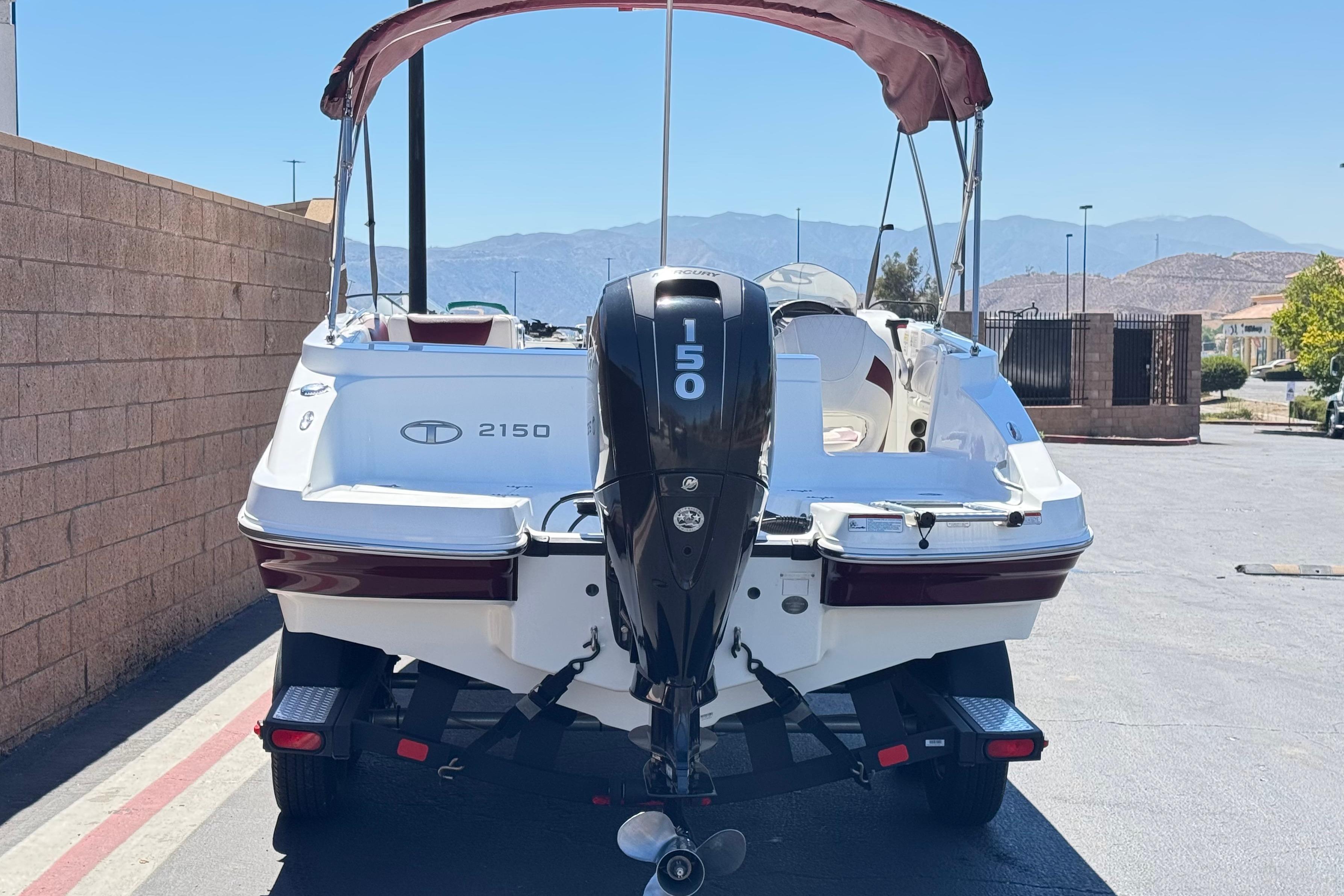 2017 Tahoe 2150 boat with 150 horsepower engine, parked outdoors on a sunny day.