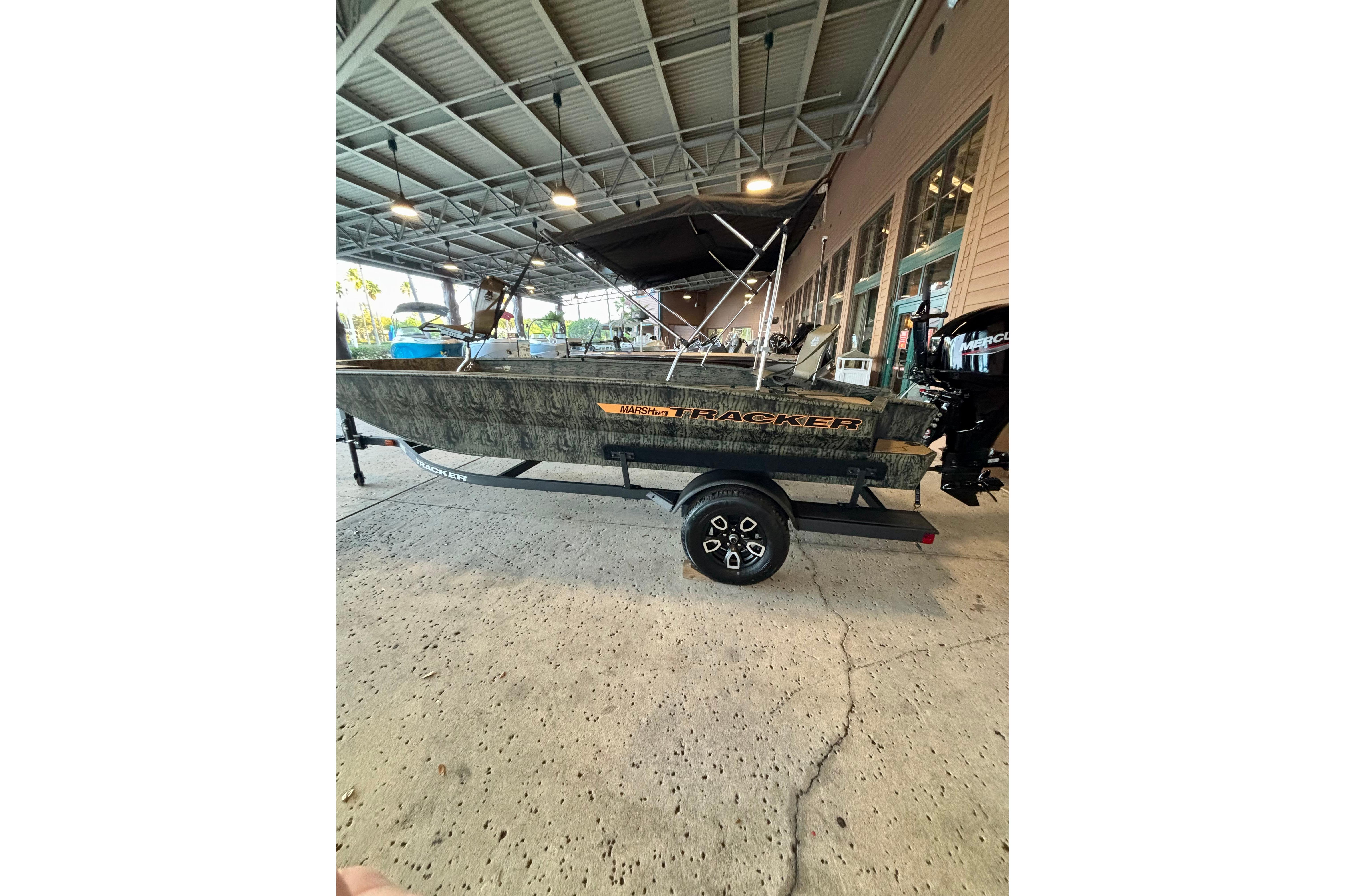 2026 Tracker Grizzly 1756 T Marsh boat on trailer under a covered area.