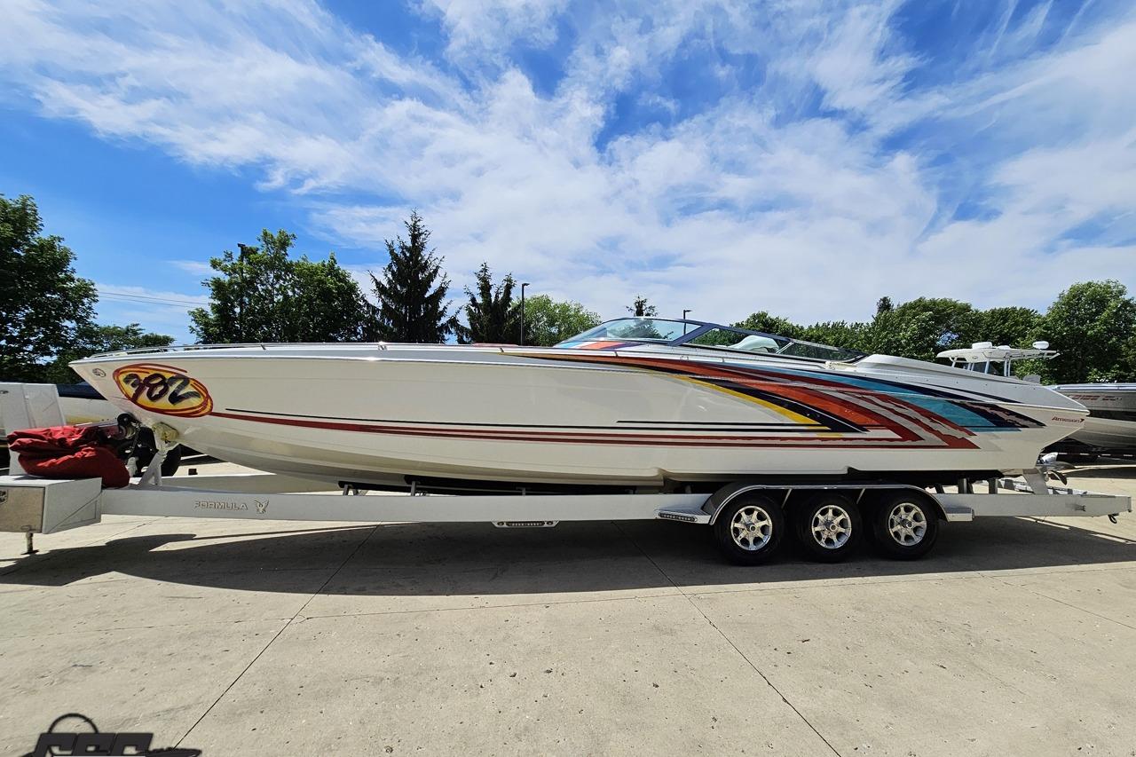 2002 Formula 382 FASTech boat on trailer under blue sky.