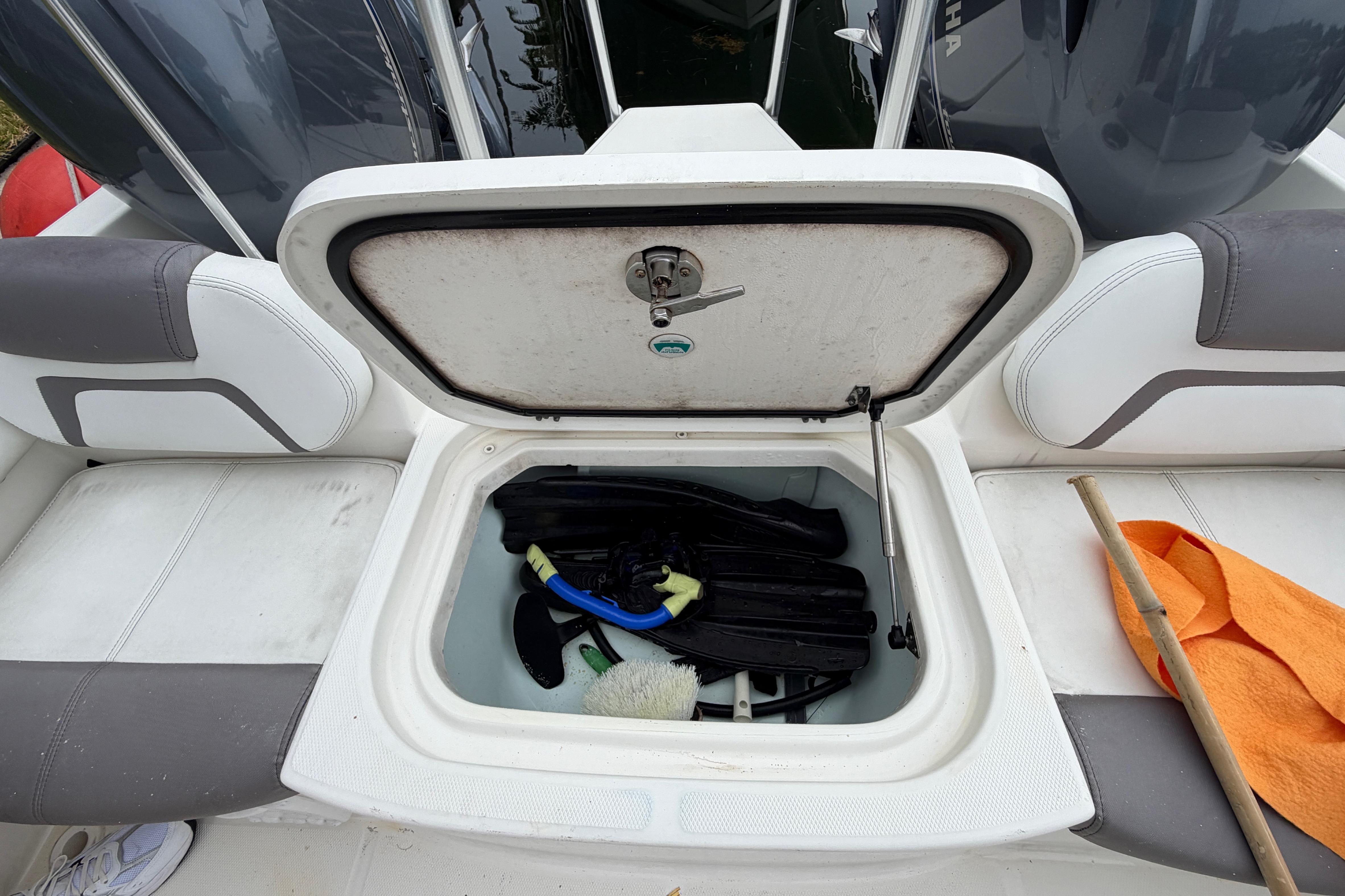 Open storage compartment on 2019 World Cat 230 DC boat with snorkeling gear inside.