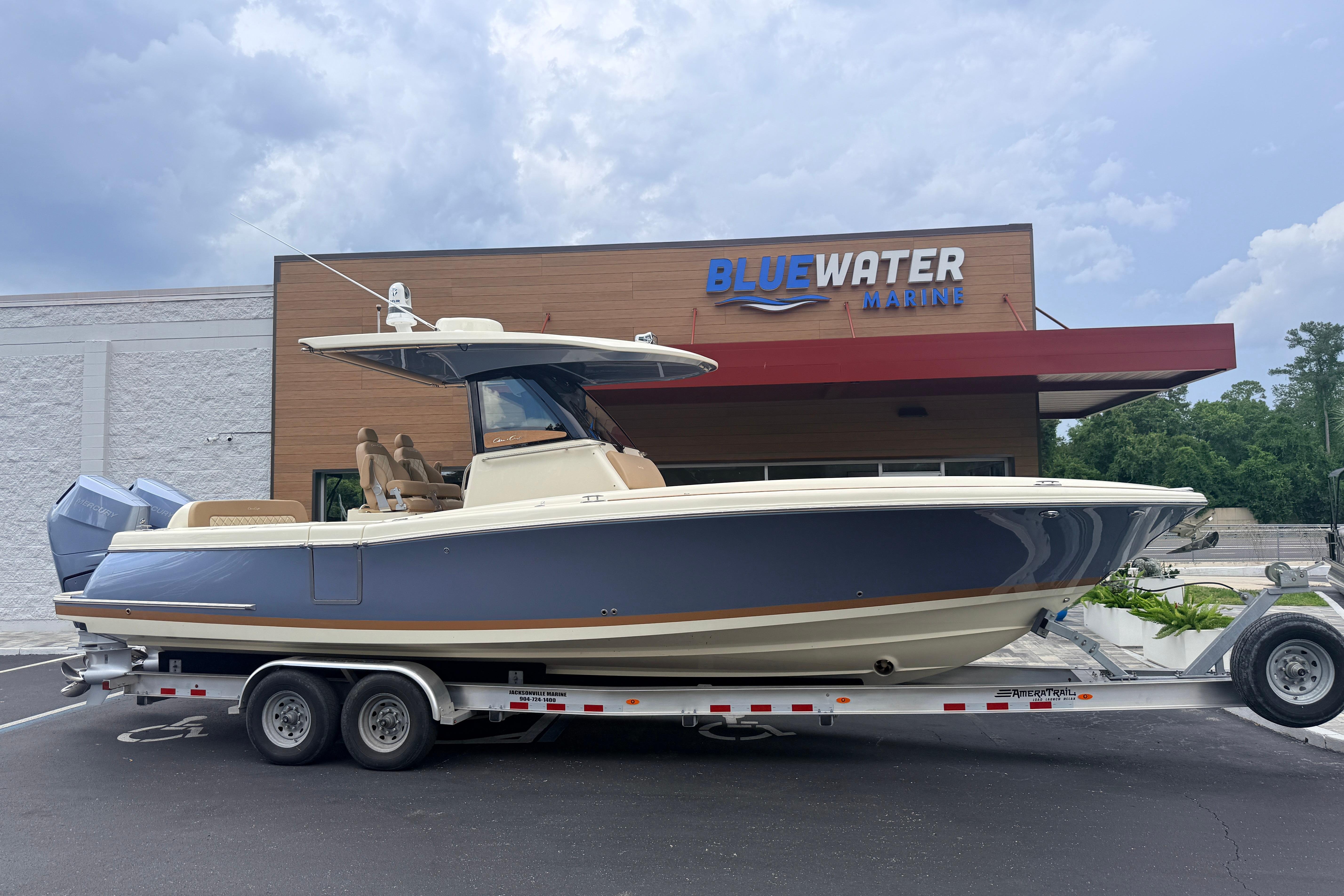 A 2024 Chris-Craft Catalina 30 boat on a trailer in front of a building.