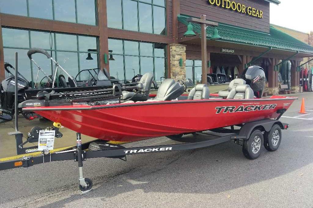 2026 Tracker Pro Team 195 boat in red, displayed outside an outdoor gear store.