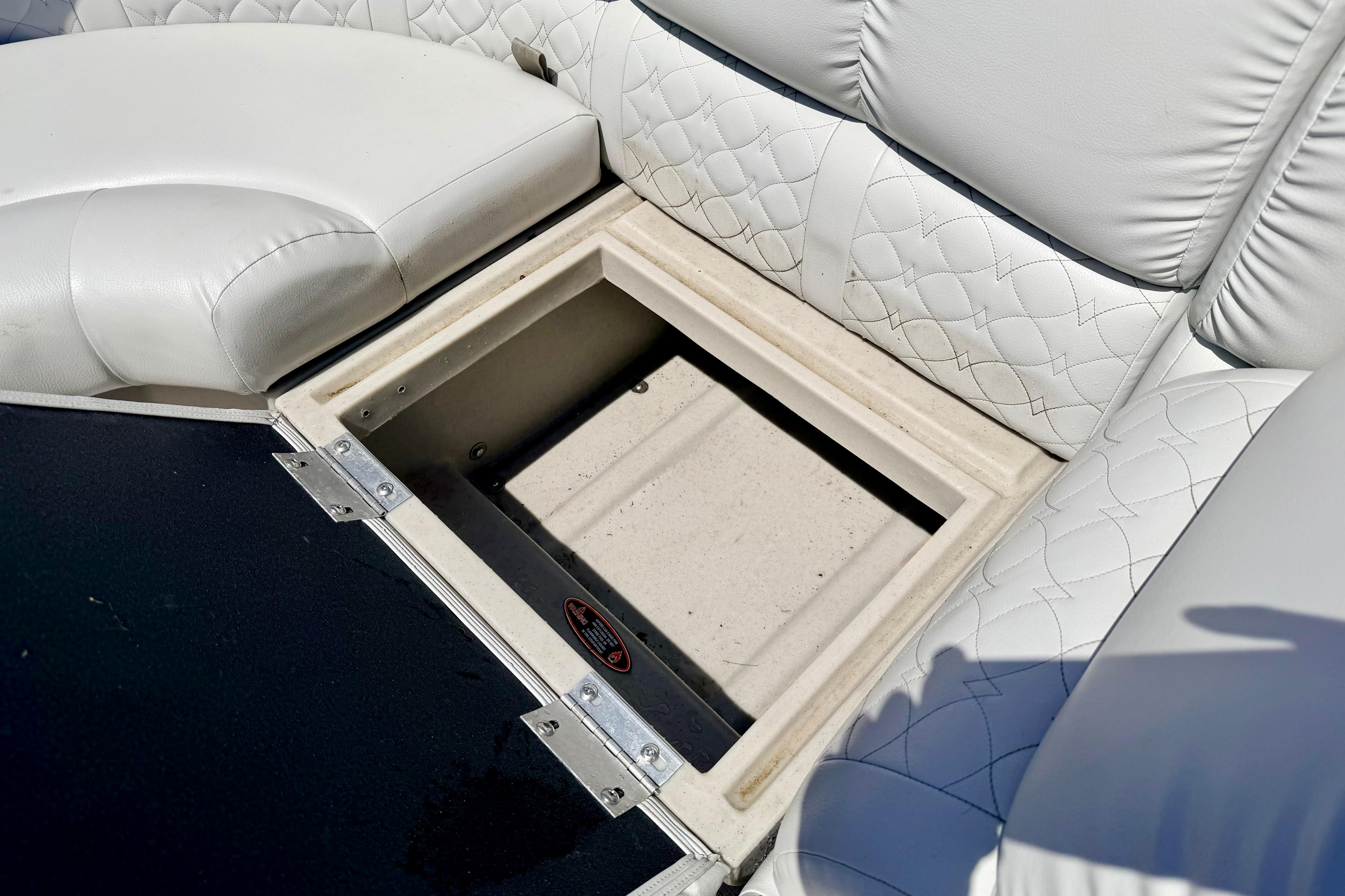 Storage compartment in 2019 Crestliner 240 Rally DX CW boat with white quilted seating.