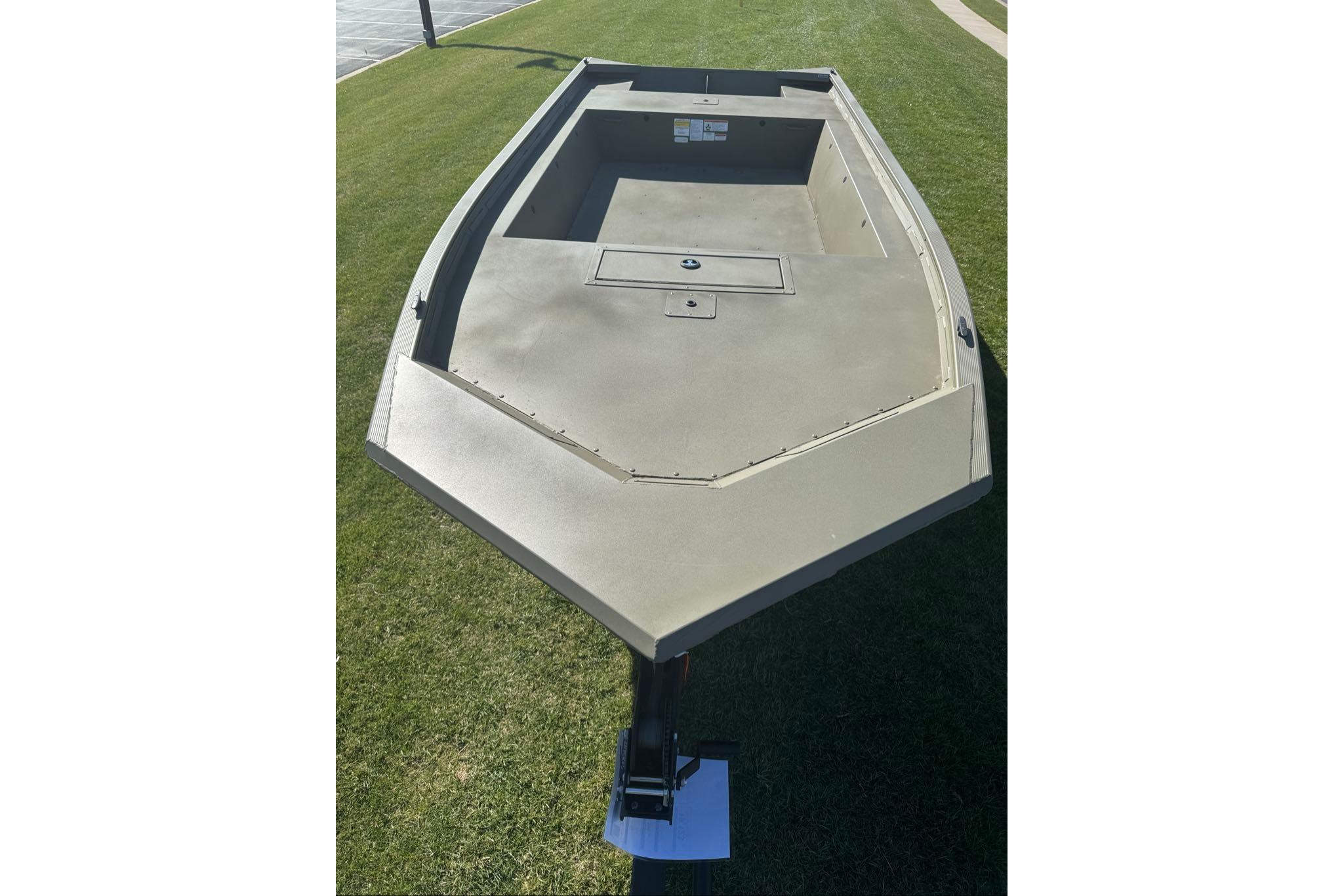 2026 Tracker Grizzly 1754 Utility boat on grass, showcasing spacious interior and sturdy design.