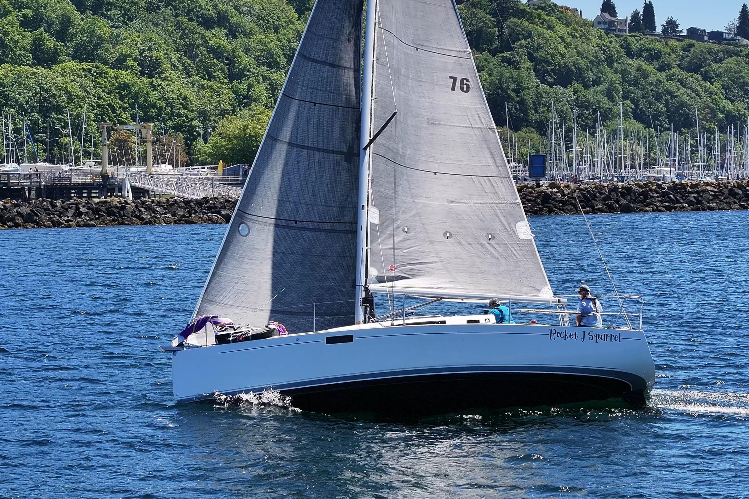 2018 J Boats J/97E sailboat cruising on a sunny day near a marina.