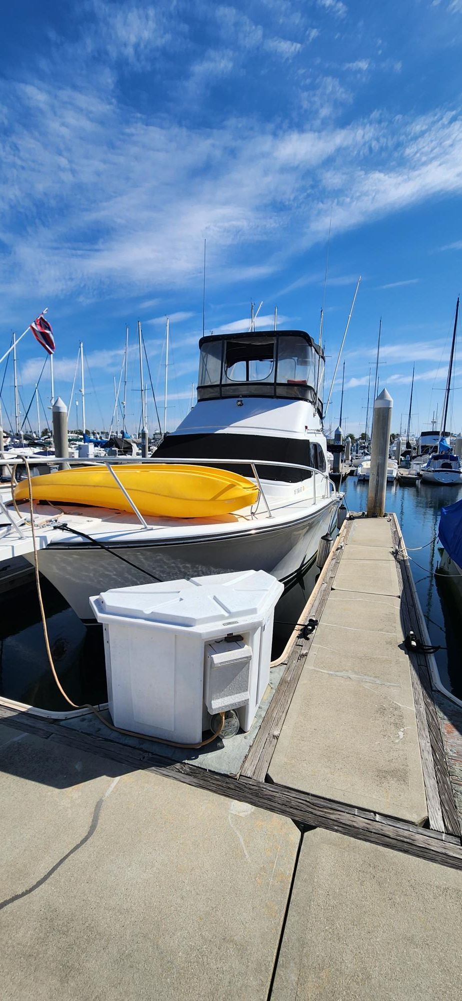 1990 Luhrs 320 boat docked in marina under blue sky.