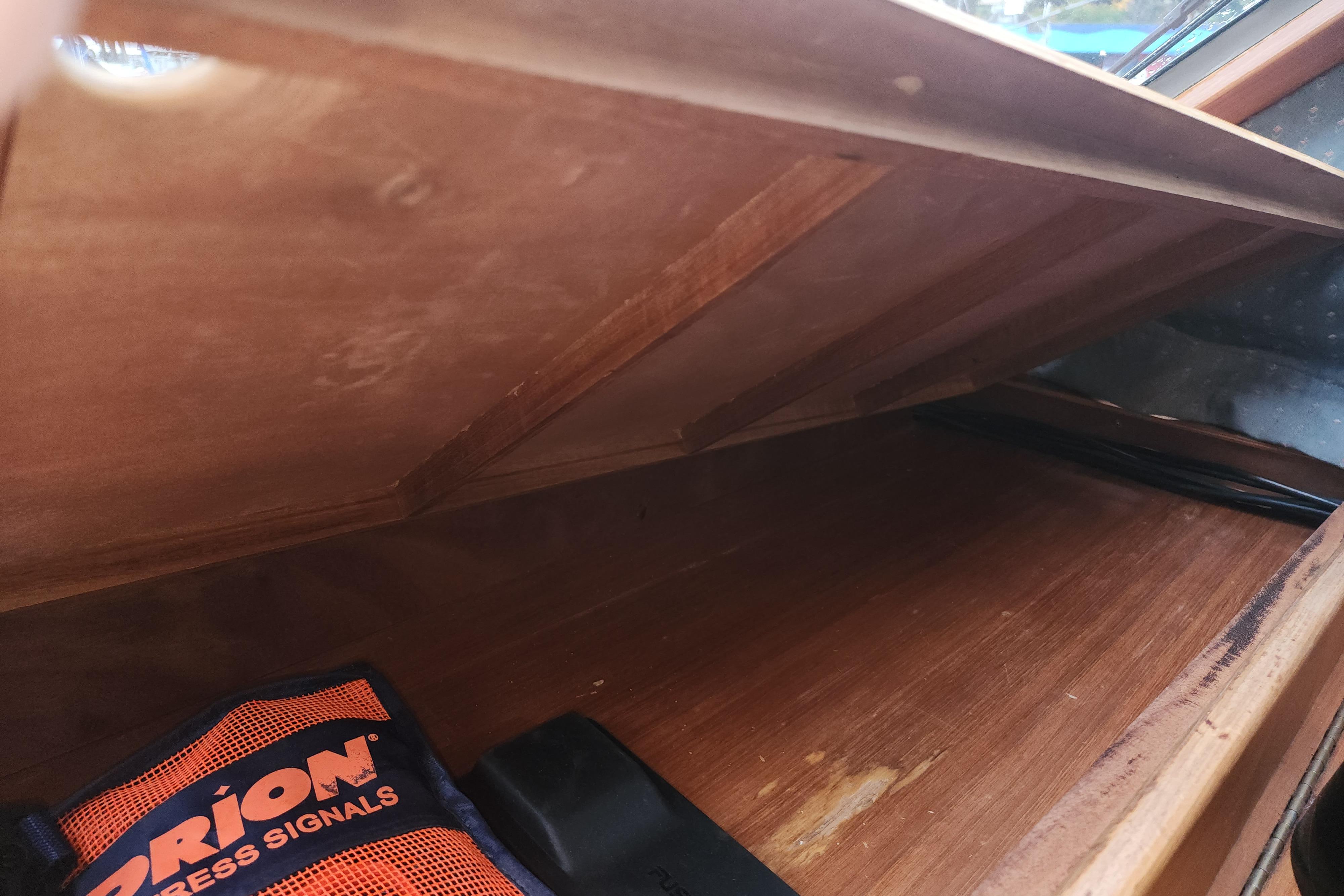 Interior storage compartment of 1991 Roughwater Sportfish boat with emergency signal kit.