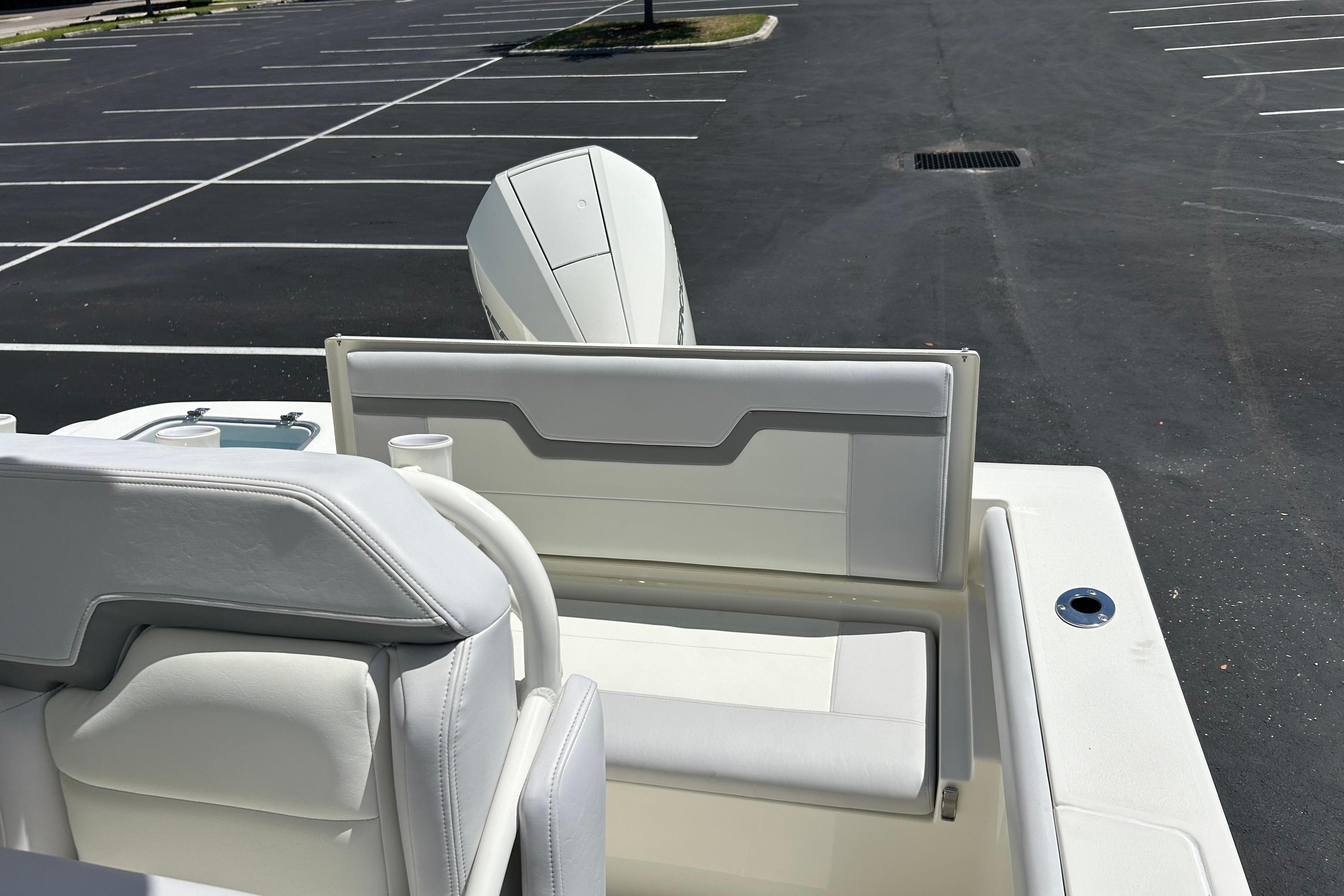 2026 Mako 226 Center Console boat interior with white seating in a parking lot.