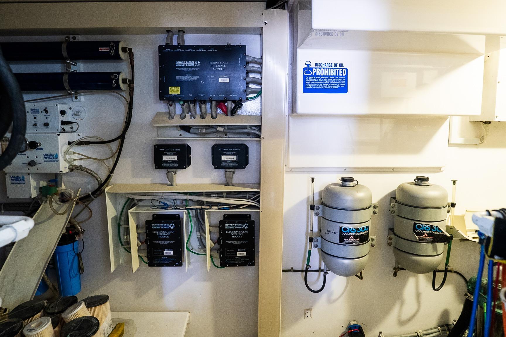 Engine room of 2002 Viking 61 Enclosed Bridge with equipment and oil discharge warning.