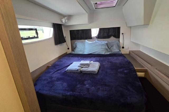 Luxurious bedroom interior of 2022 Fountaine Pajot Tanna 47 yacht with cozy bedding.