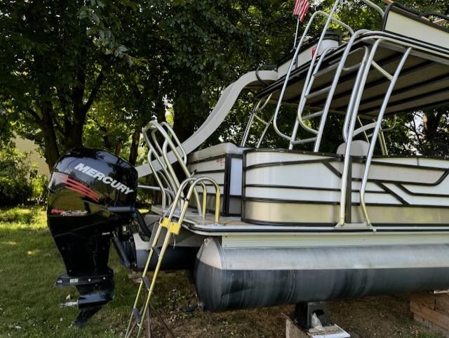 2017 Crest Caribbean 250 L pontoon boat with Mercury outboard motor, parked on grass.