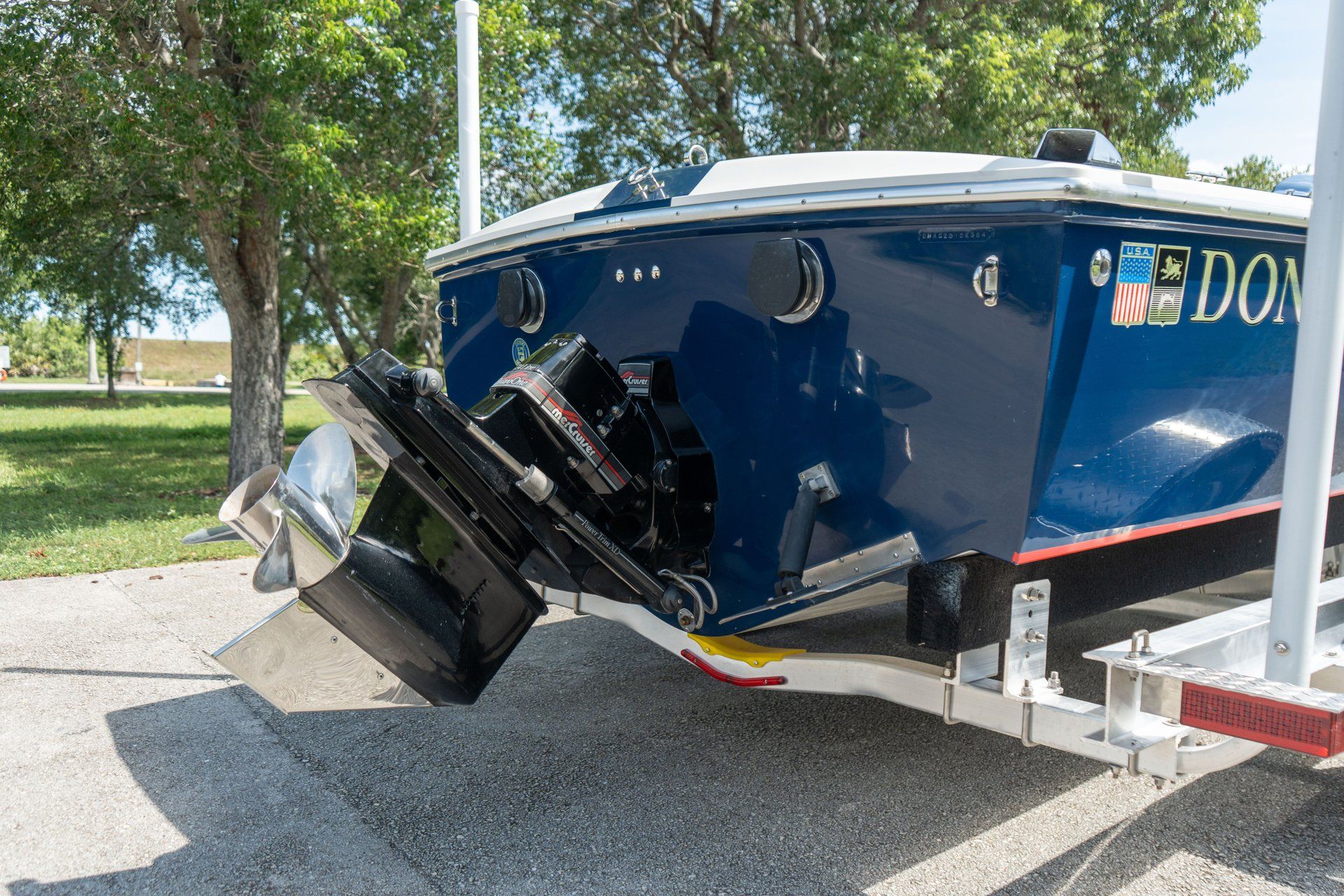 A Donzi 22 Classic boat on a trailer, surrounded by trees.