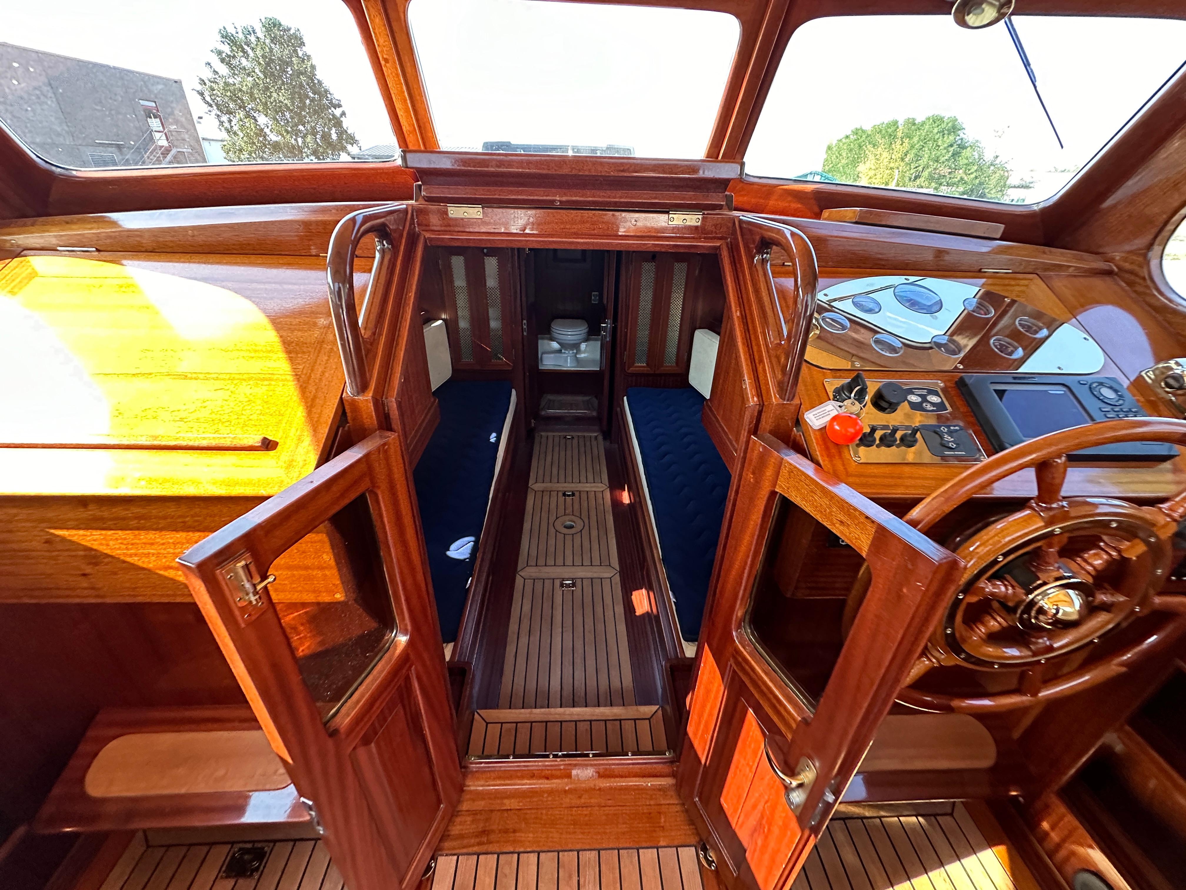 Interior of 2005 Breedendam MTB 31 boat with wooden finish and steering wheel.