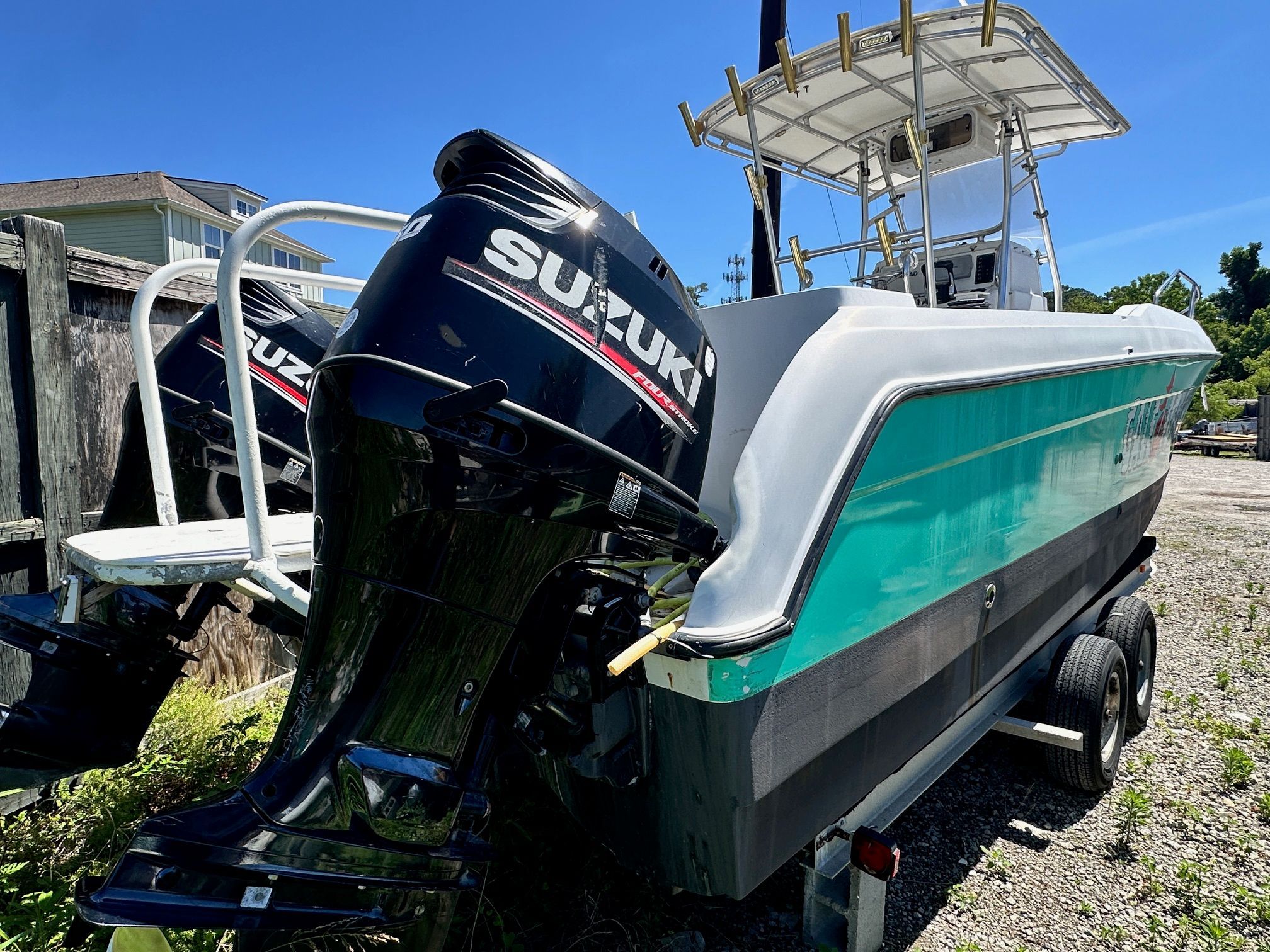 1999 Glacier Bay 260 Canyon Runner with Suzuki engines on trailer.