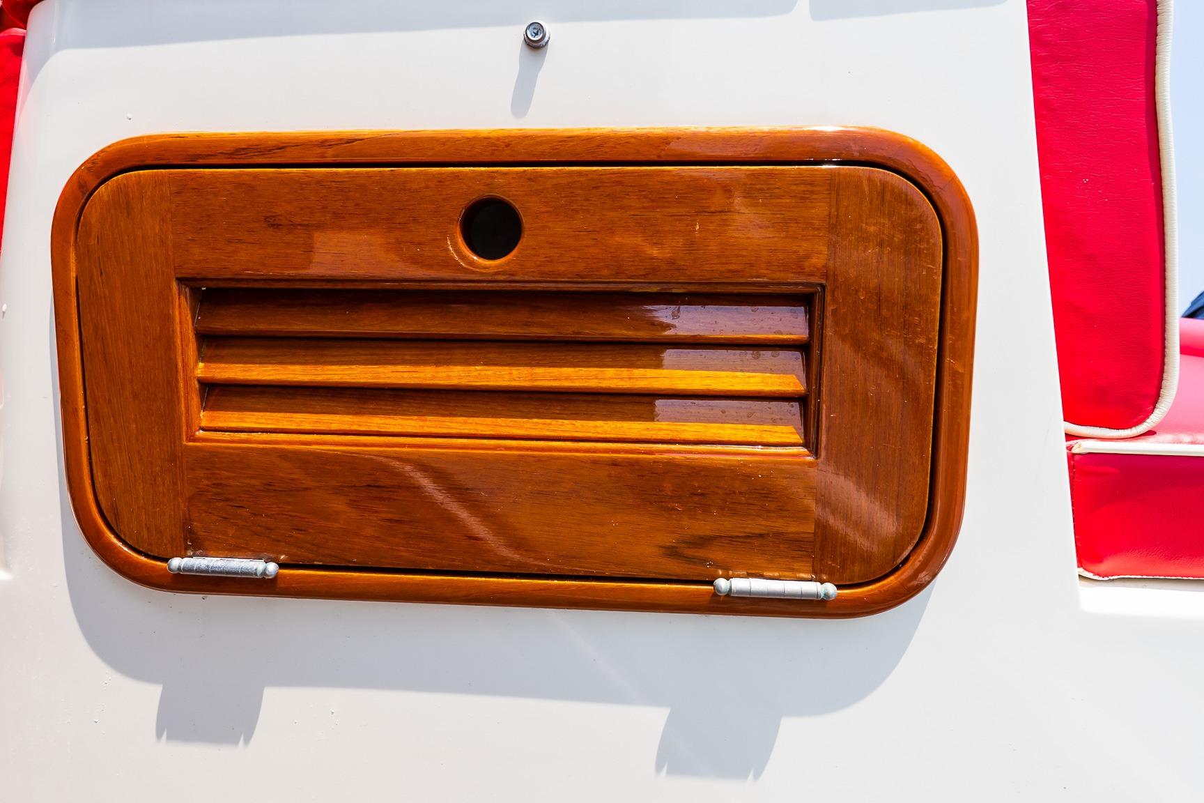 Close-up of a 2005 Hinckley Talaria 29R wooden hatch with red seating.