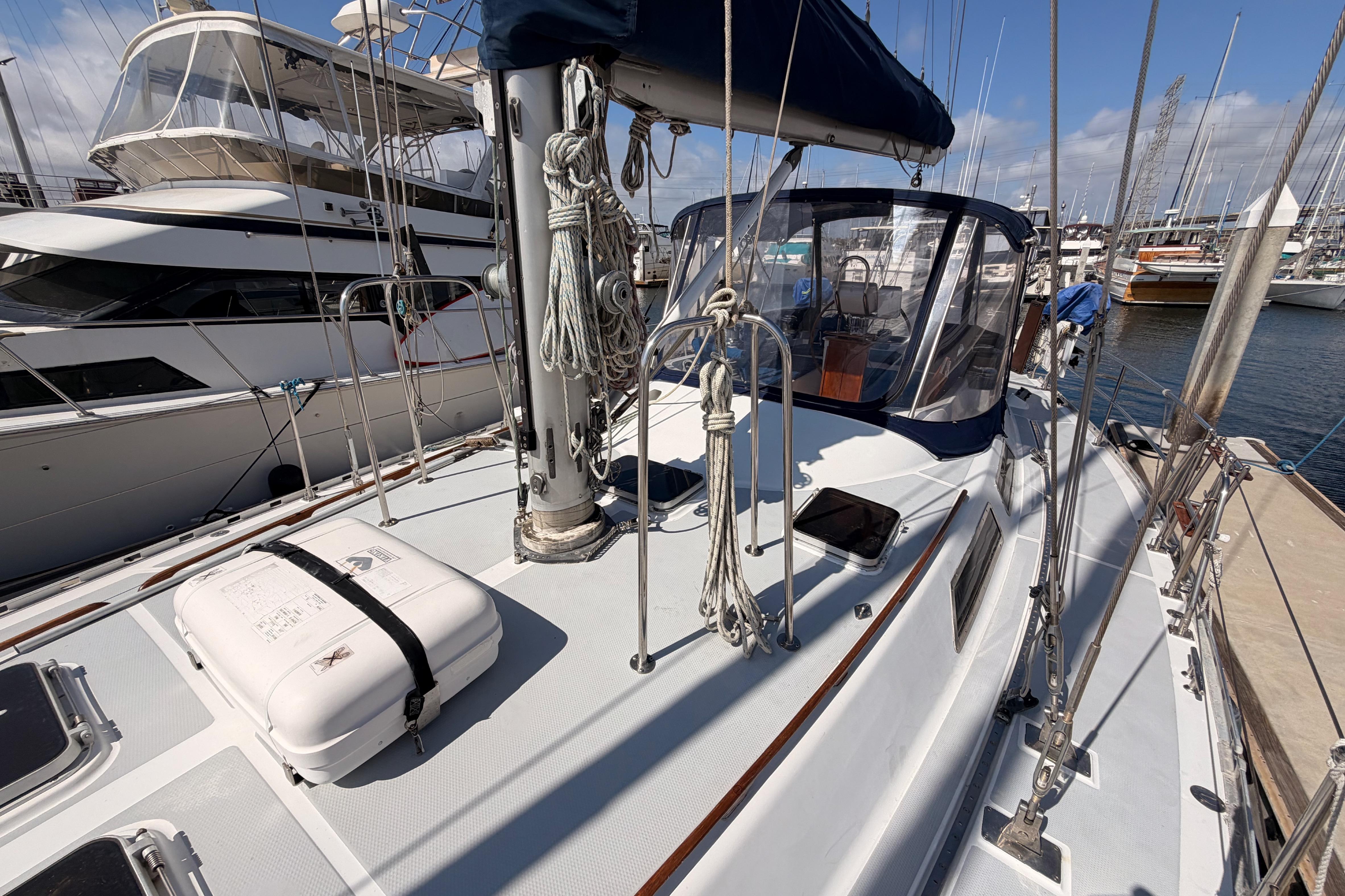 Sailboat deck of a 1991 Hylas 51, docked at a marina under clear skies.