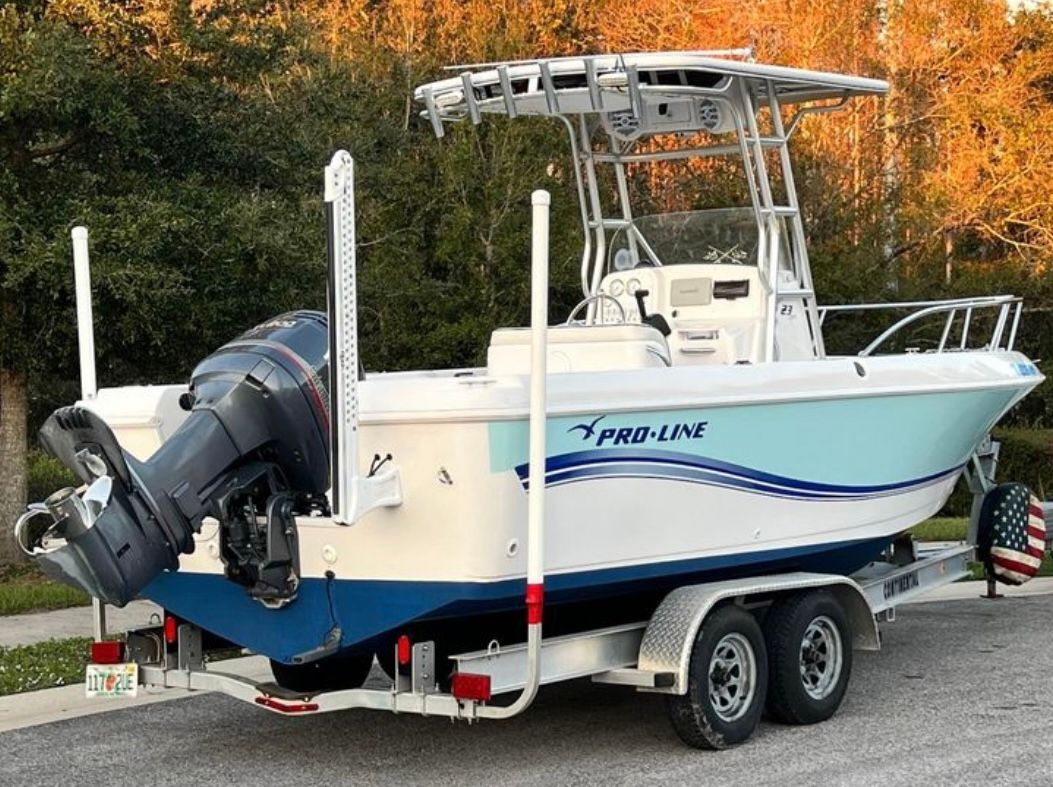 A 2005 Pro-Line 23 Sport boat on a trailer, featuring an outboard motor and T-top.