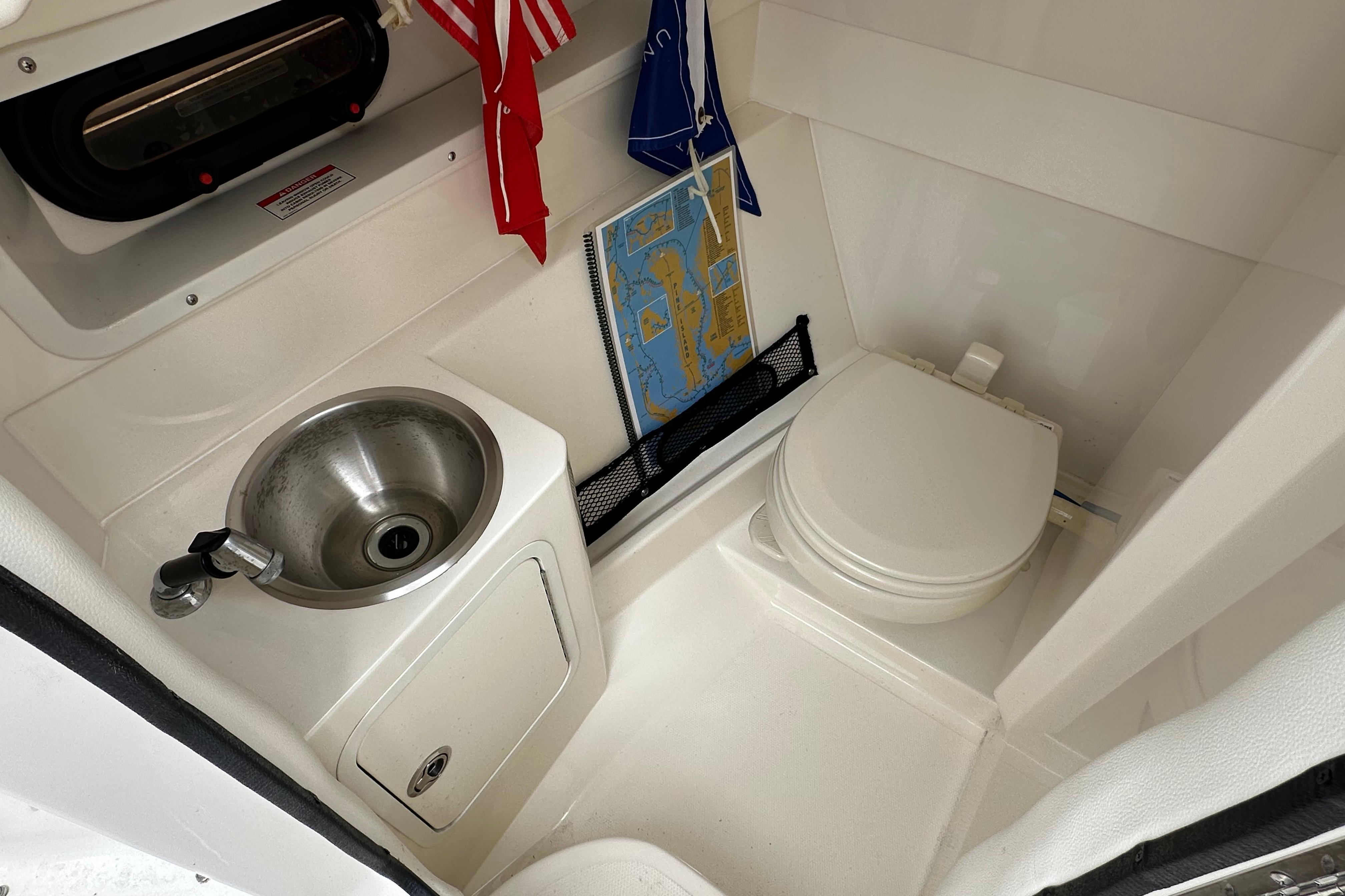 Interior of 2016 Sea Ray 270 Sundeck boat with sink and toilet.