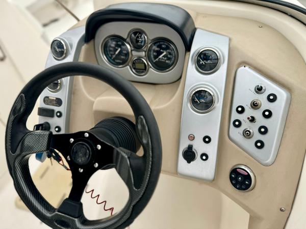 2006 Larson LXi 248 boat dashboard with steering wheel and gauges.