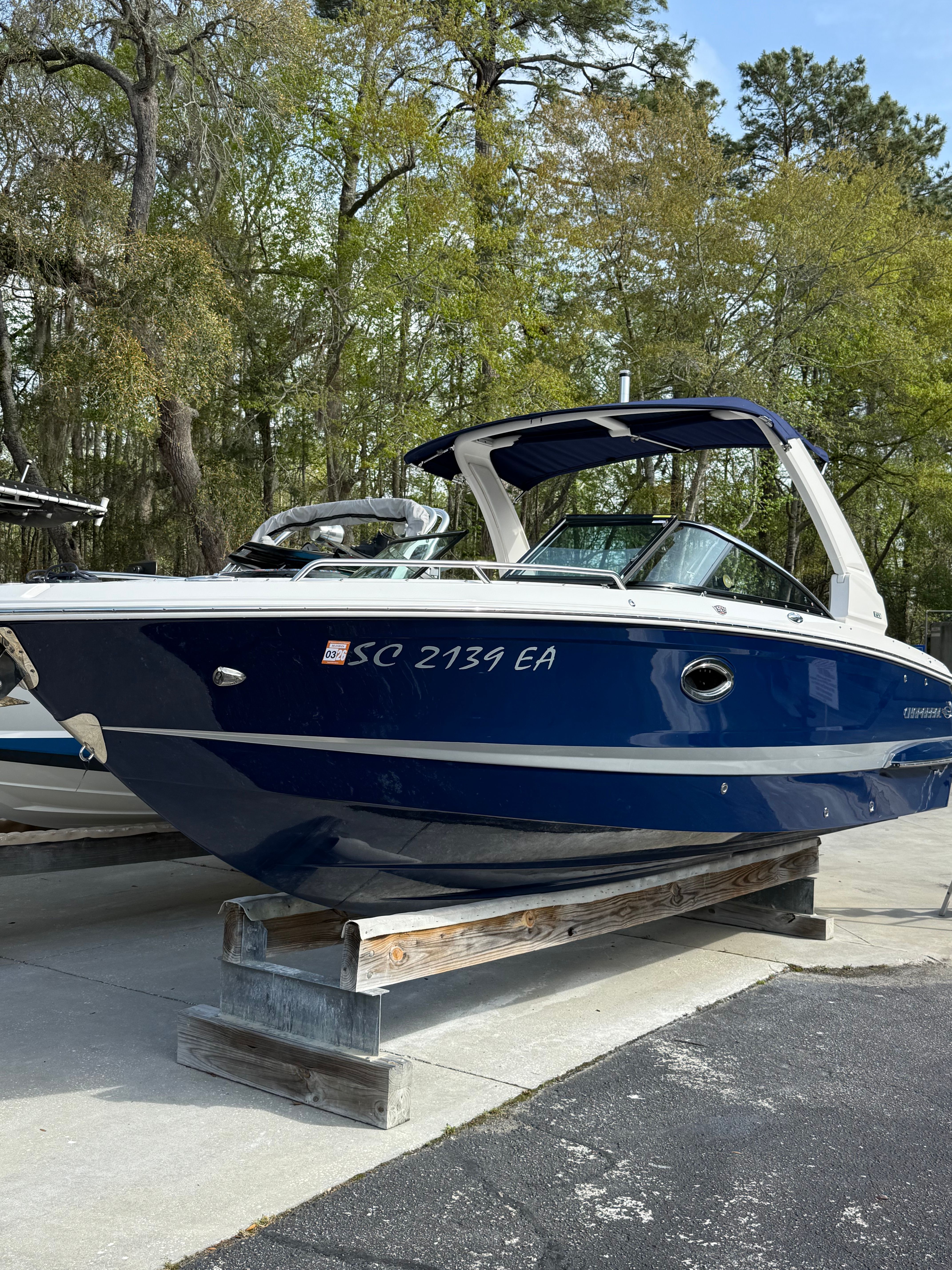 2020 Chaparral 256 SSX boat on a wooden stand outdoors.