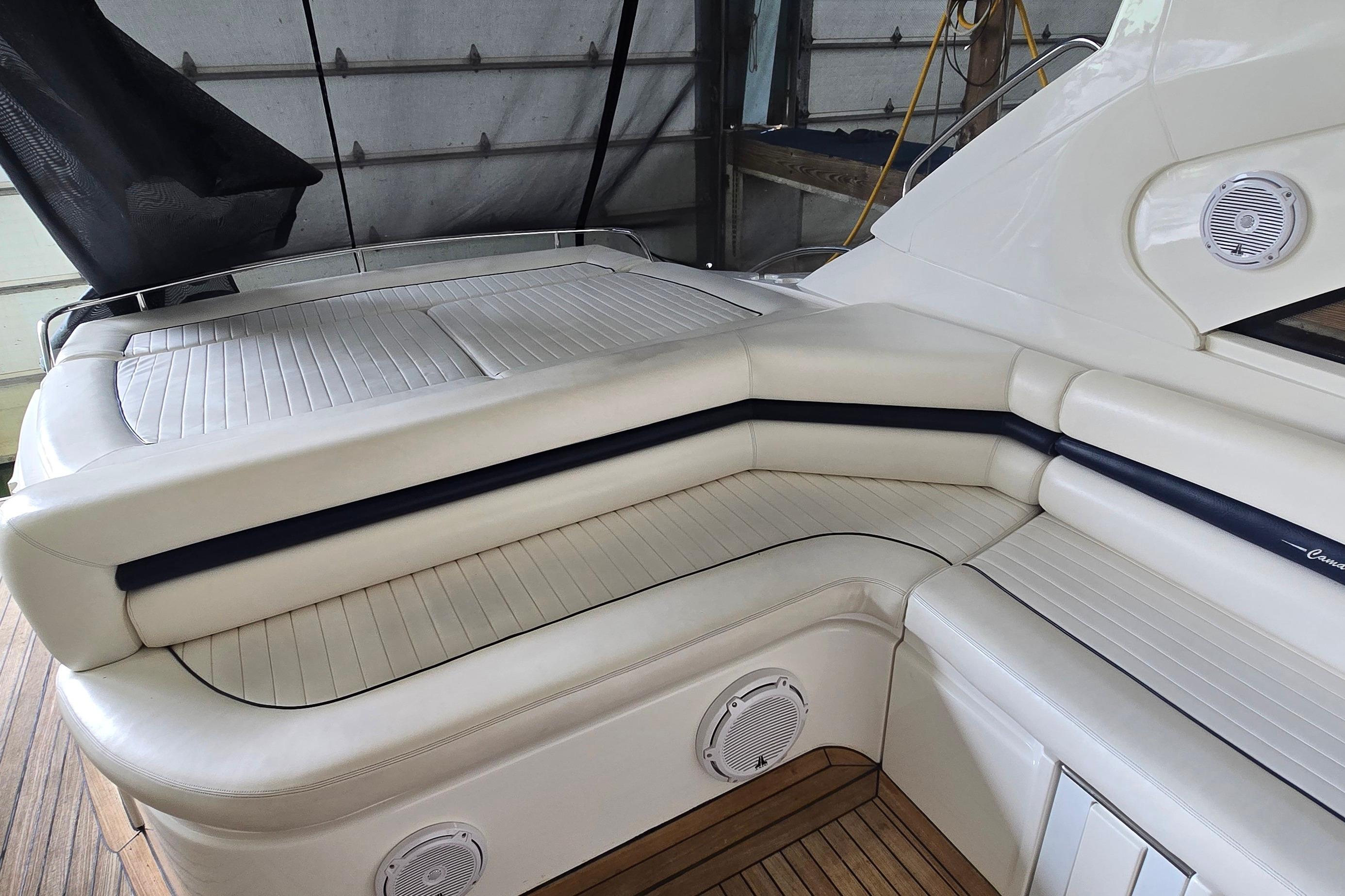Luxurious seating area on a 2004 Sunseeker Camargue 50 yacht, featuring elegant white upholstery.