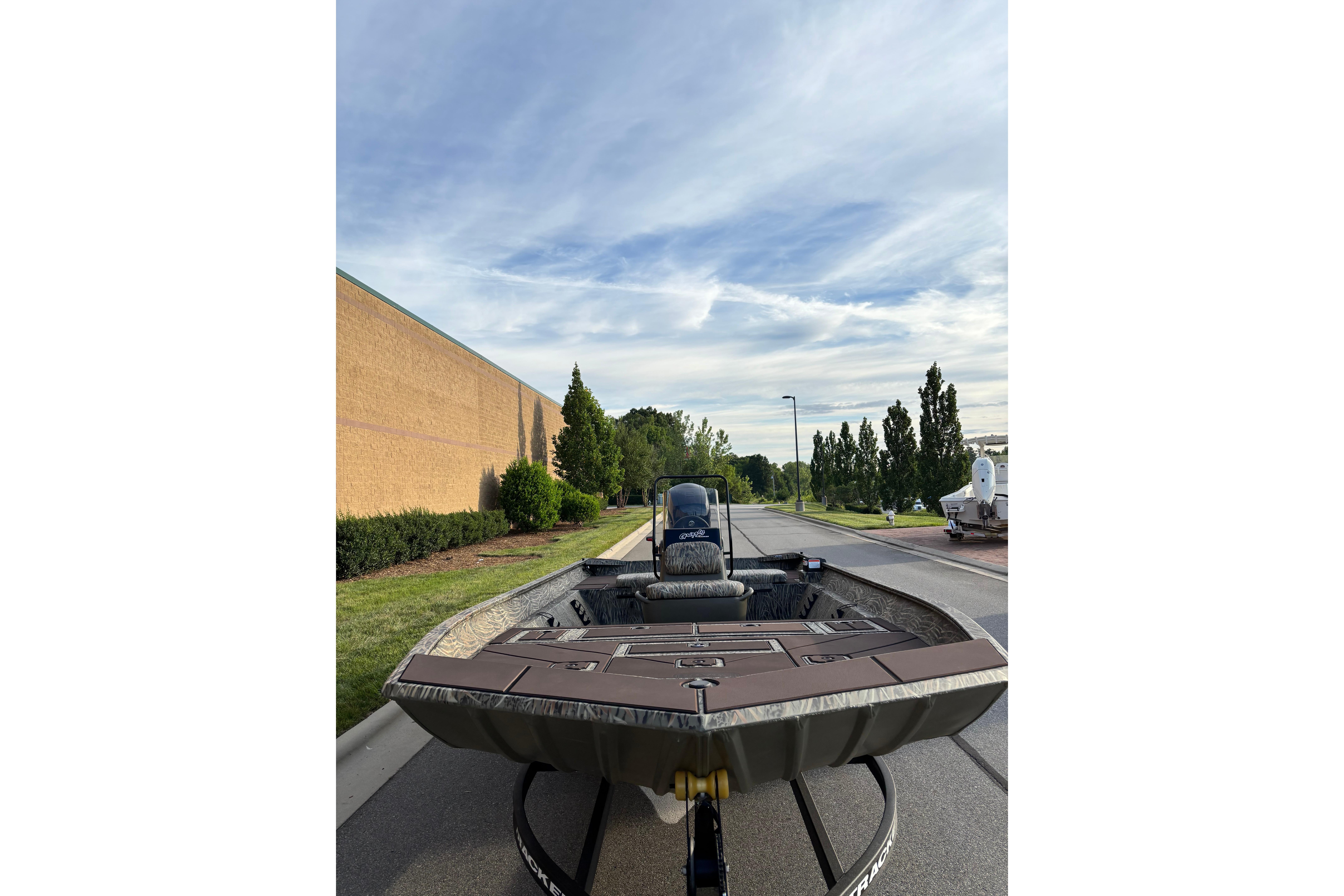2026 Tracker Grizzly 2072 CC boat on trailer, parked outdoors under a blue sky.