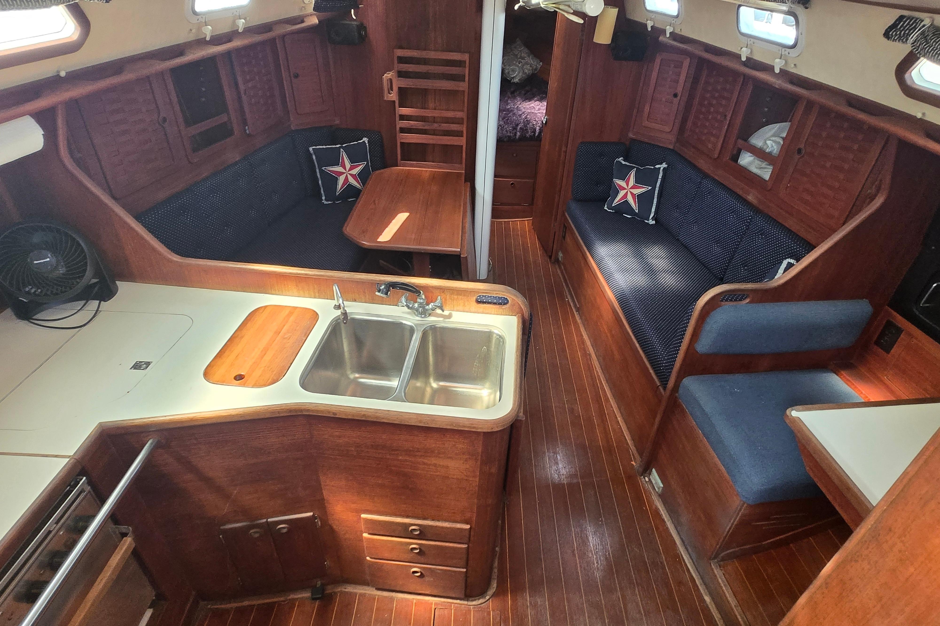 Interior of 1988 Sabre 38 sailboat with wood finish and cozy seating area.