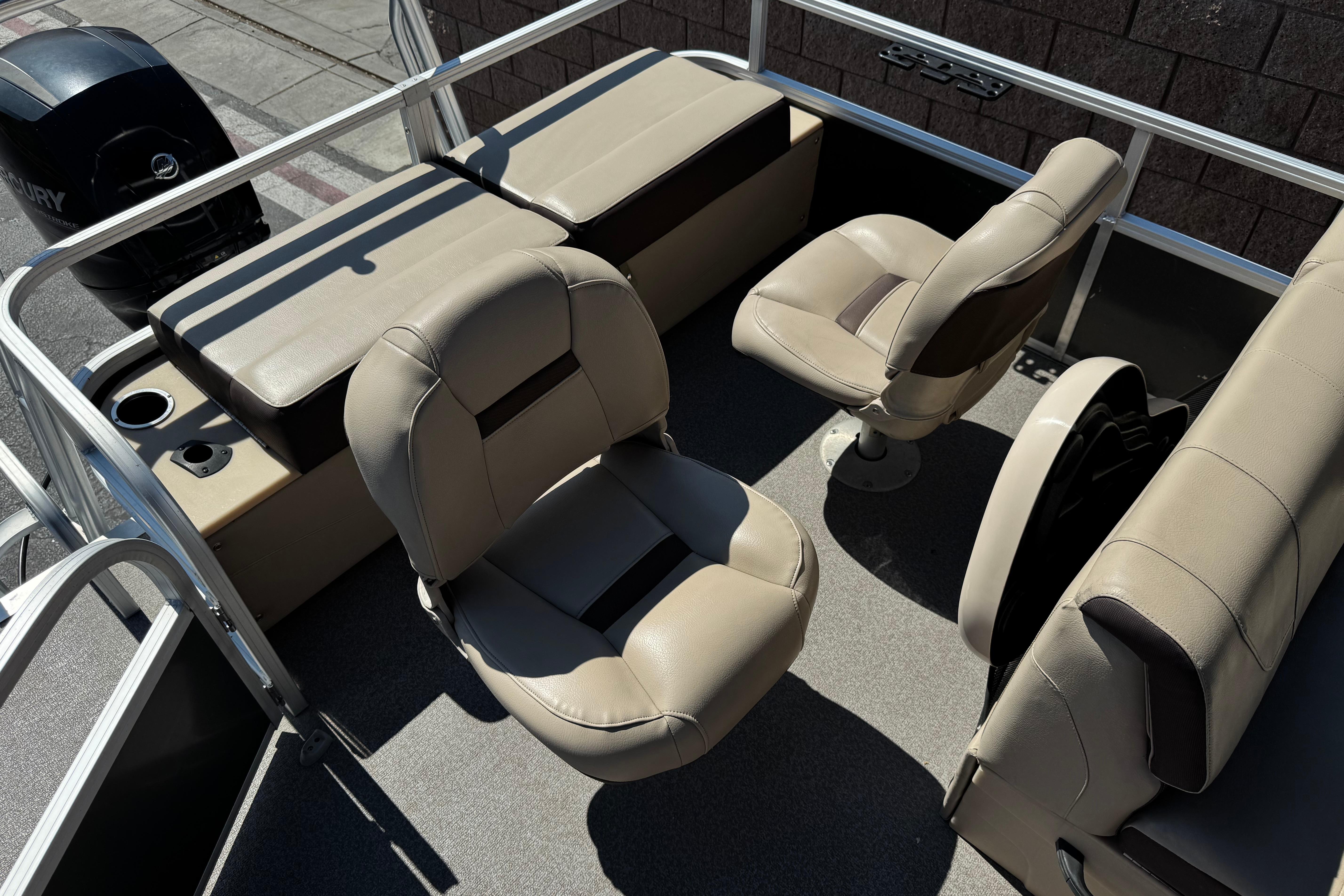 2018 Sun Tracker SportFish 22 DLX interior with beige seating and Mercury outboard motor.