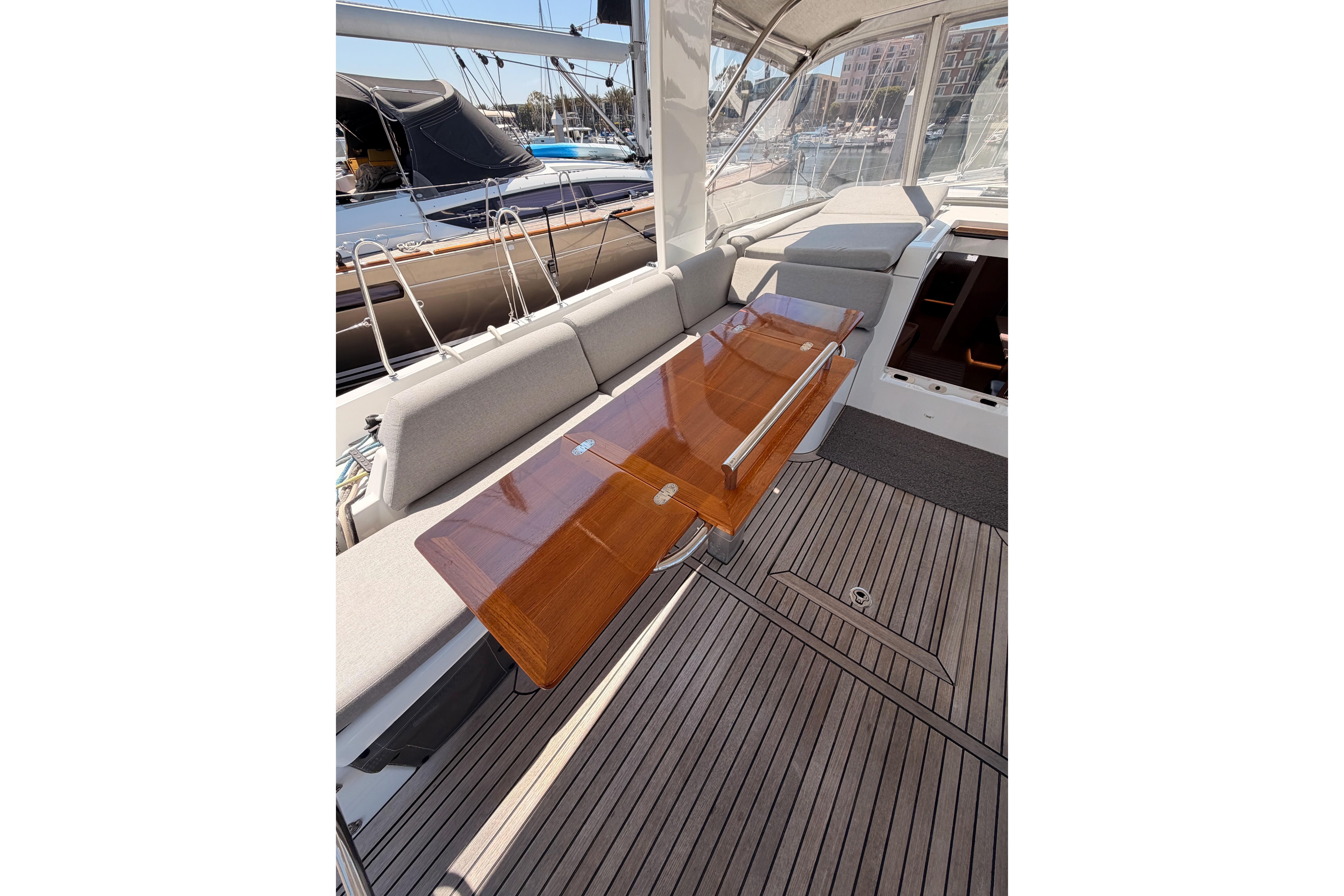 Luxurious 2022 Beneteau Oceanis Yacht 54 cockpit with elegant wooden table and comfortable seating.