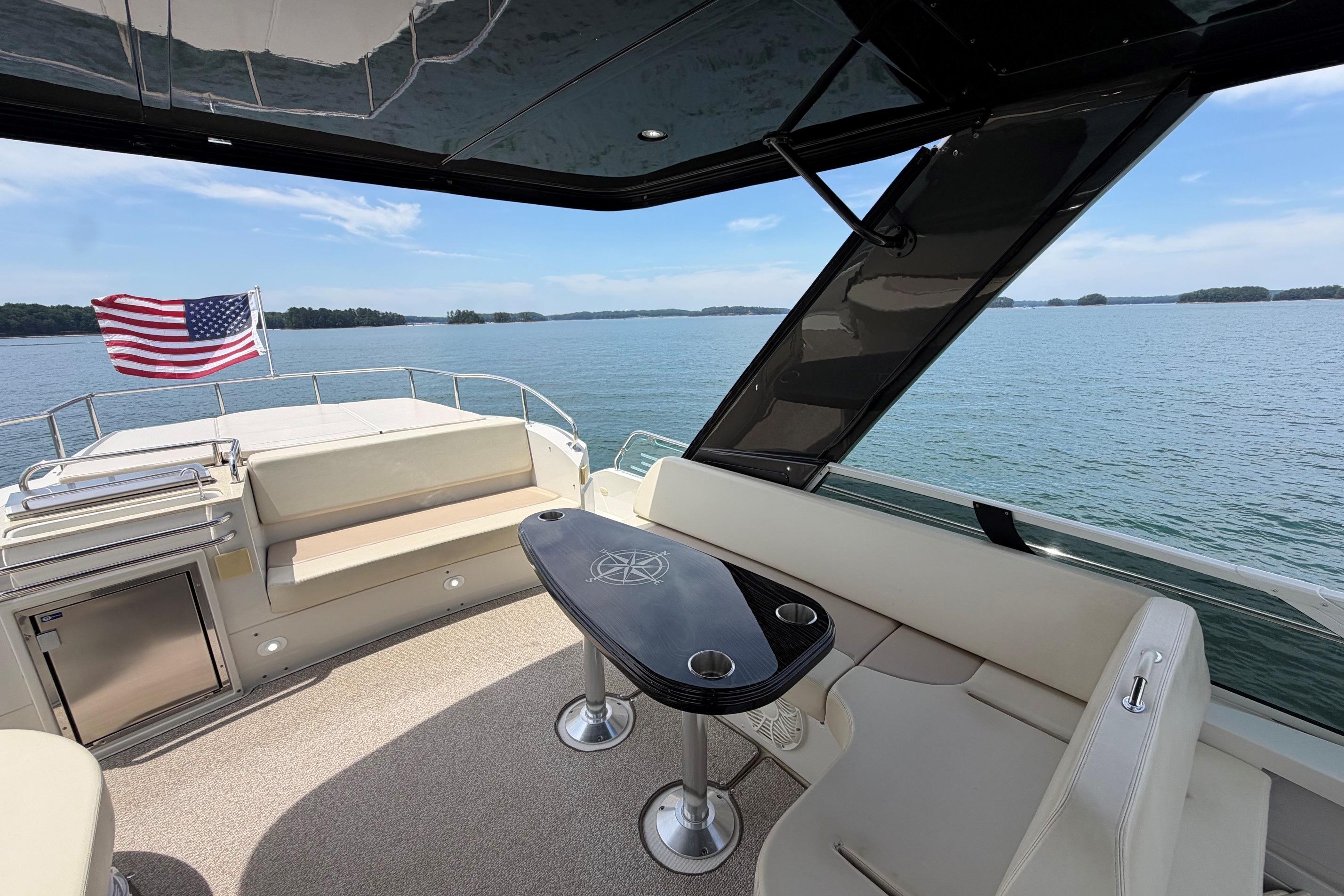 Luxurious 2011 Carver 44 Sojourn yacht interior with American flag, overlooking serene waters.