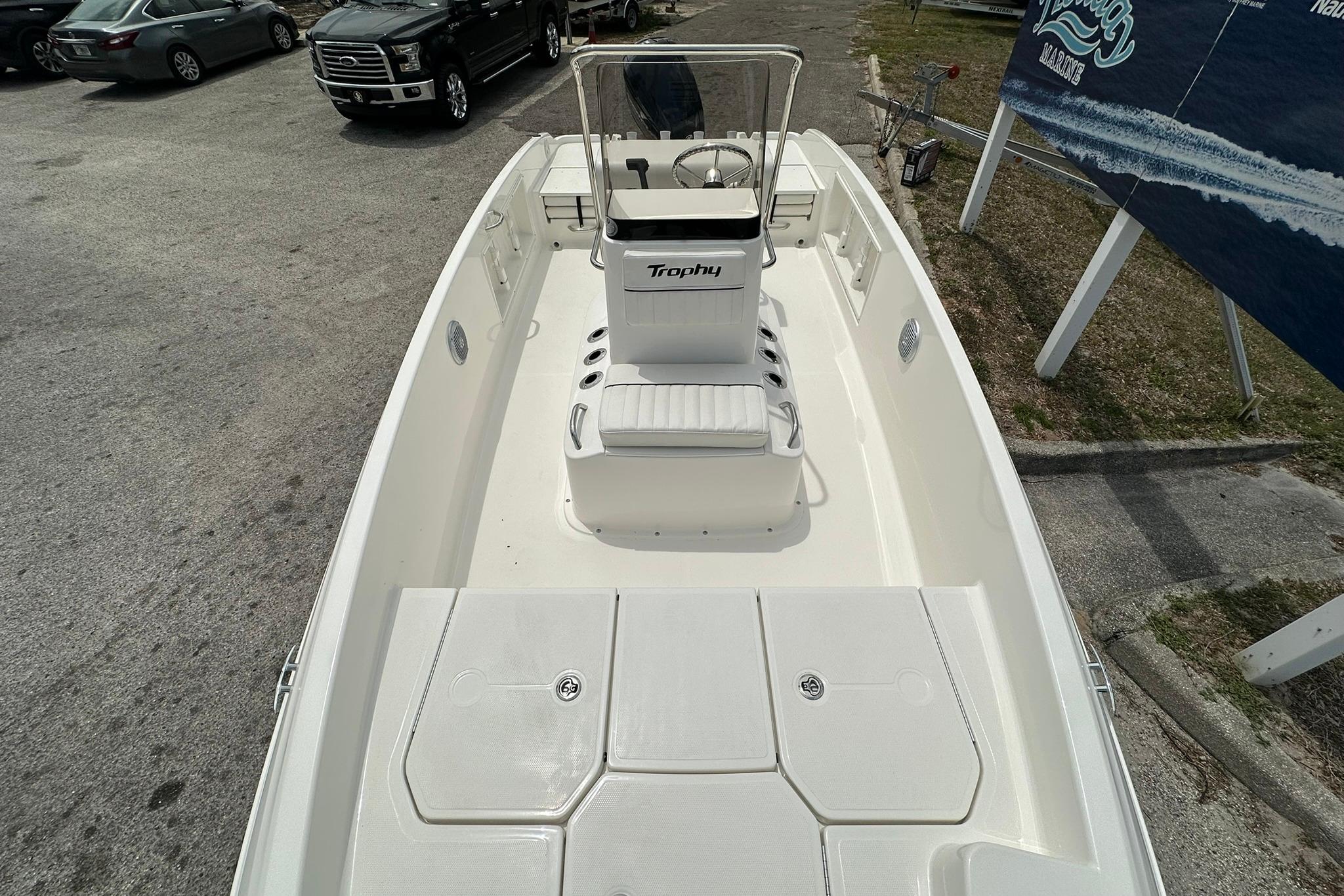 2026 Bayliner Trophy T18 boat, white interior, parked outdoors, showcasing seating and steering console.