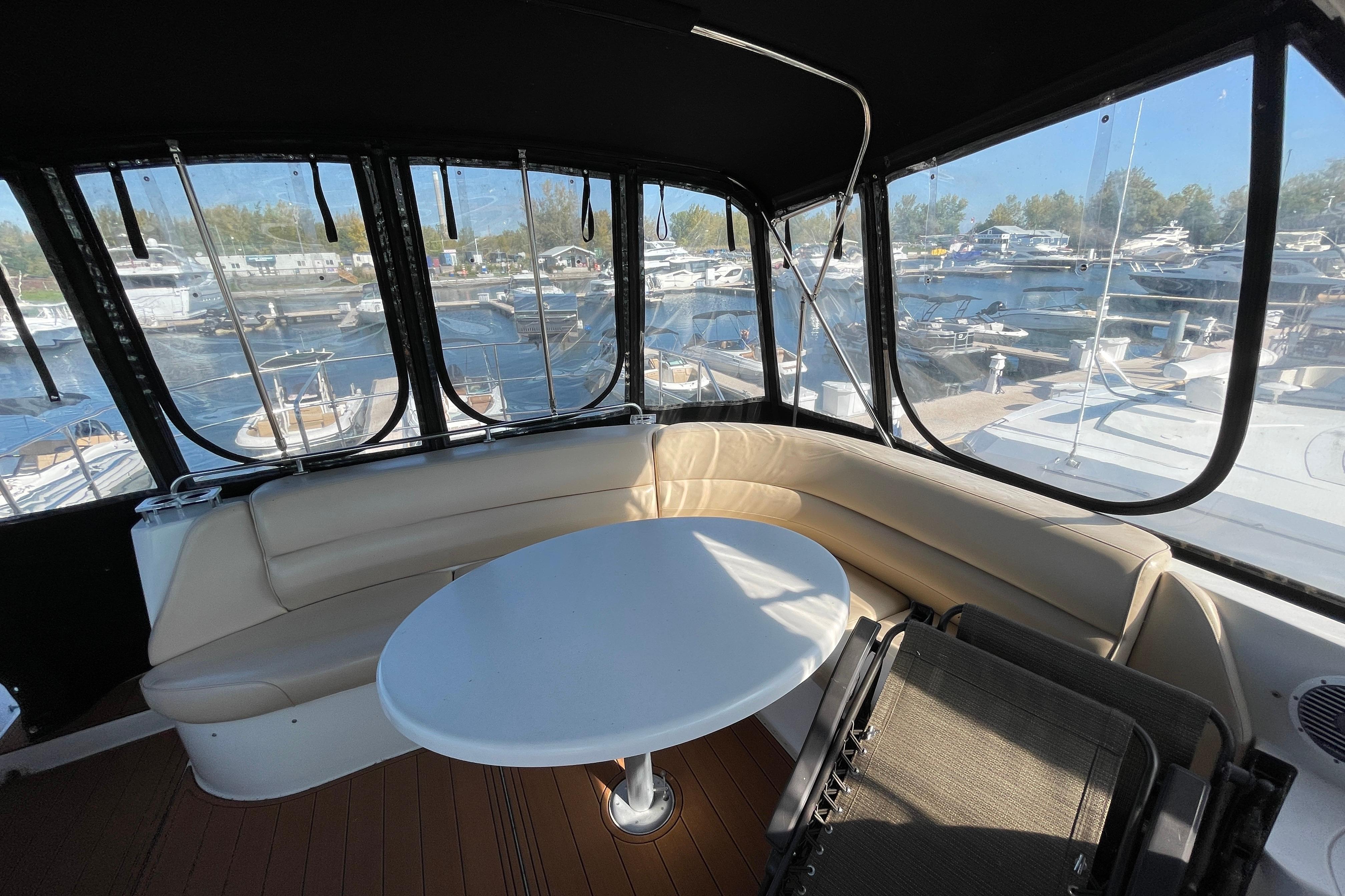 Luxurious 2002 Carver 570 Voyager Pilothouse yacht interior with seating and marina view.