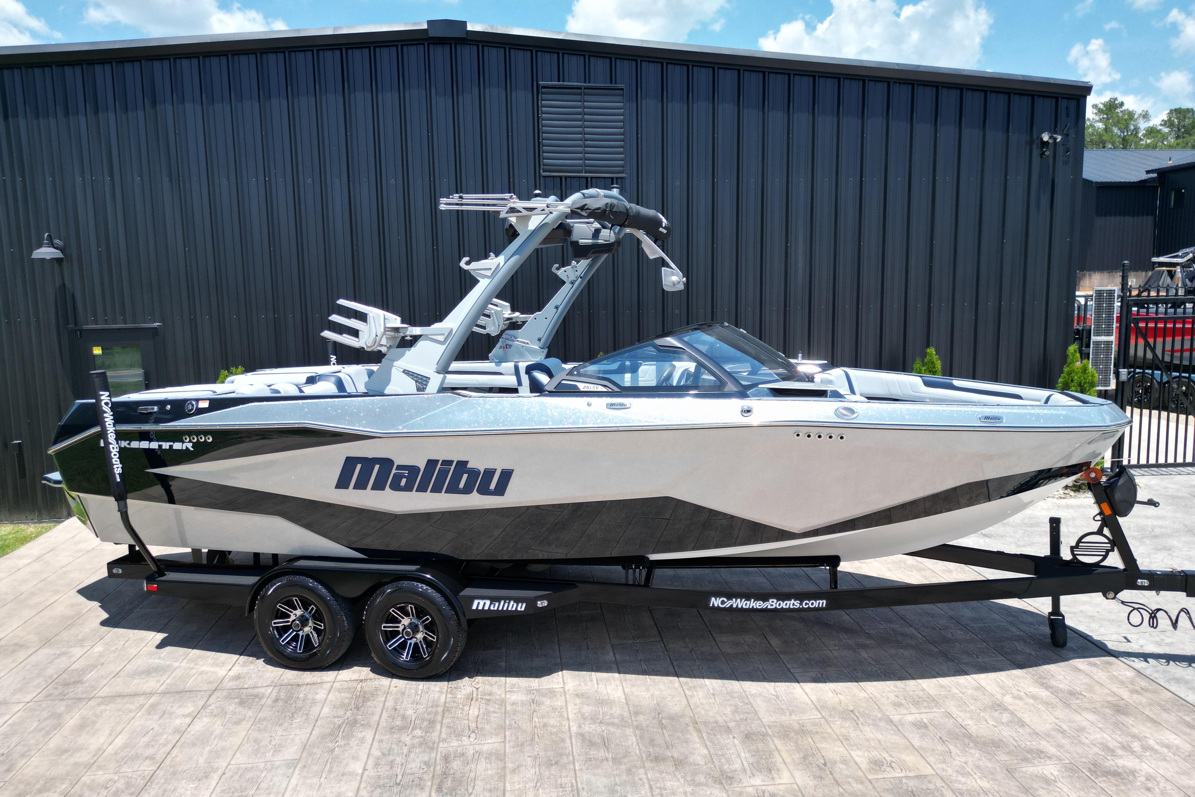 2025 Malibu Wakesetter 25 LSV boat on trailer, sleek design, parked outdoors.