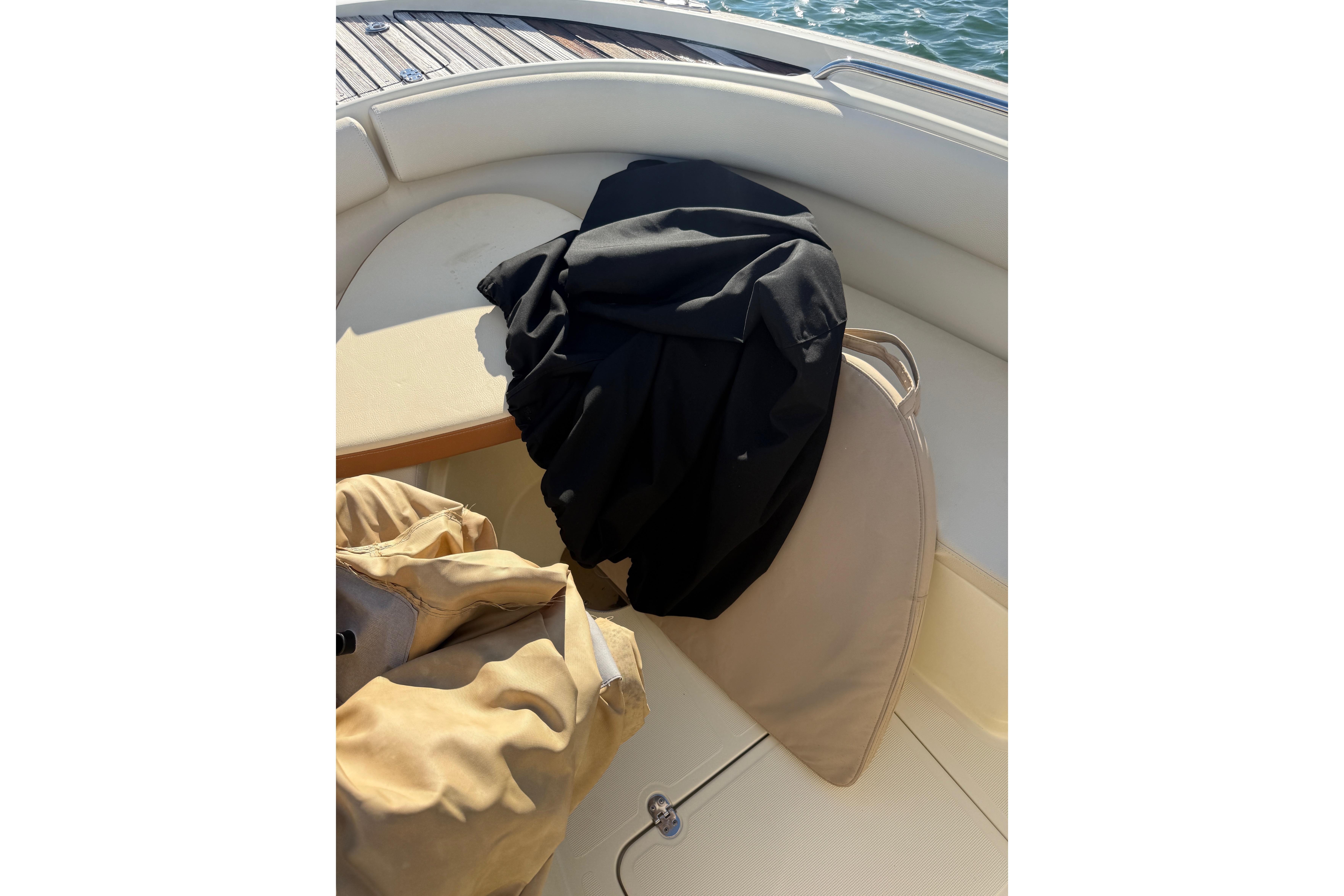 2013 Chris-Craft Catalina 26 boat interior with cushions and clothing on deck.