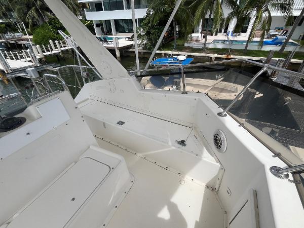 1985 Hatteras 45 Convertible yacht deck with seating, docked near waterfront homes.