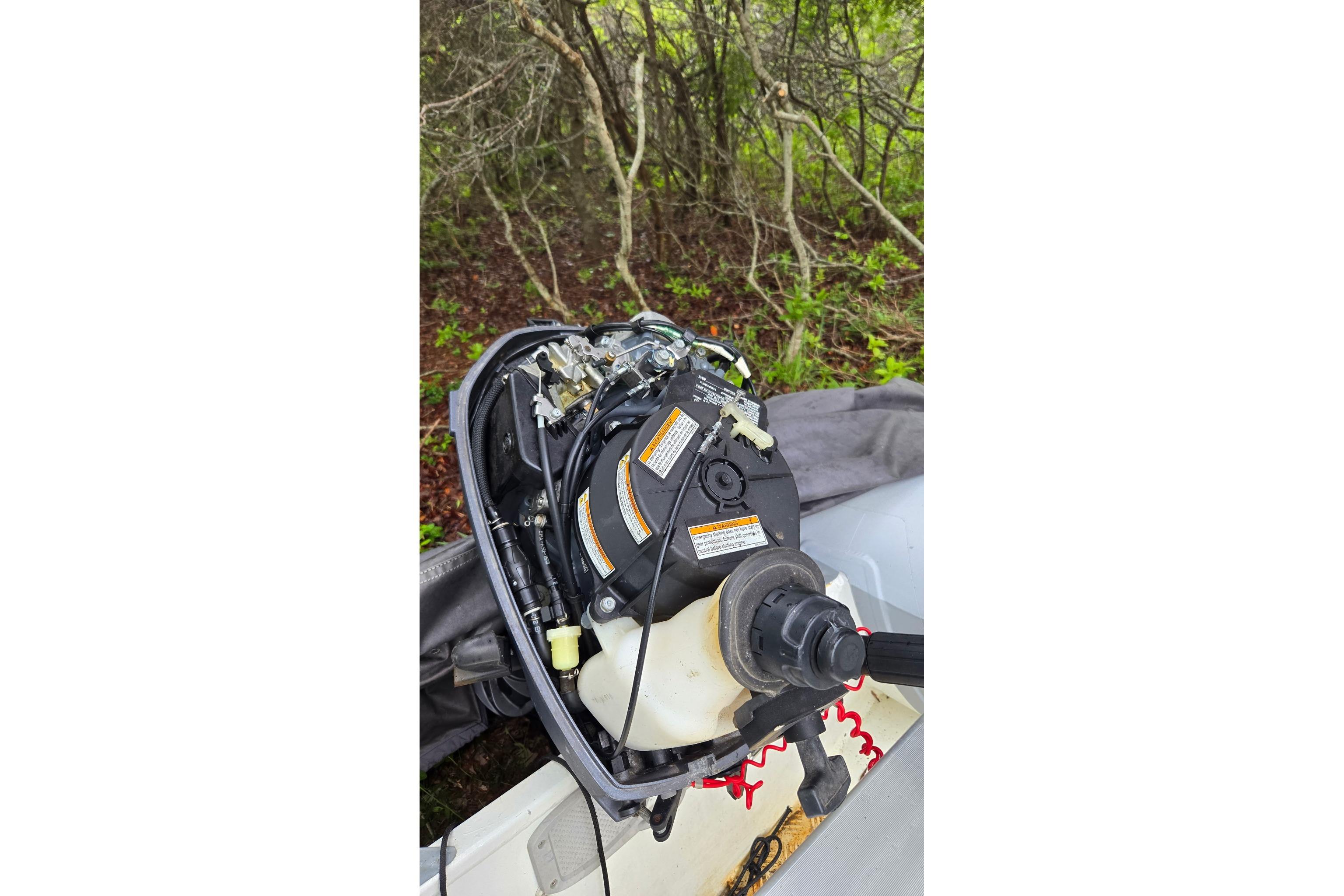 Outboard motor of a 1987 Marine Trader 36, surrounded by lush greenery.