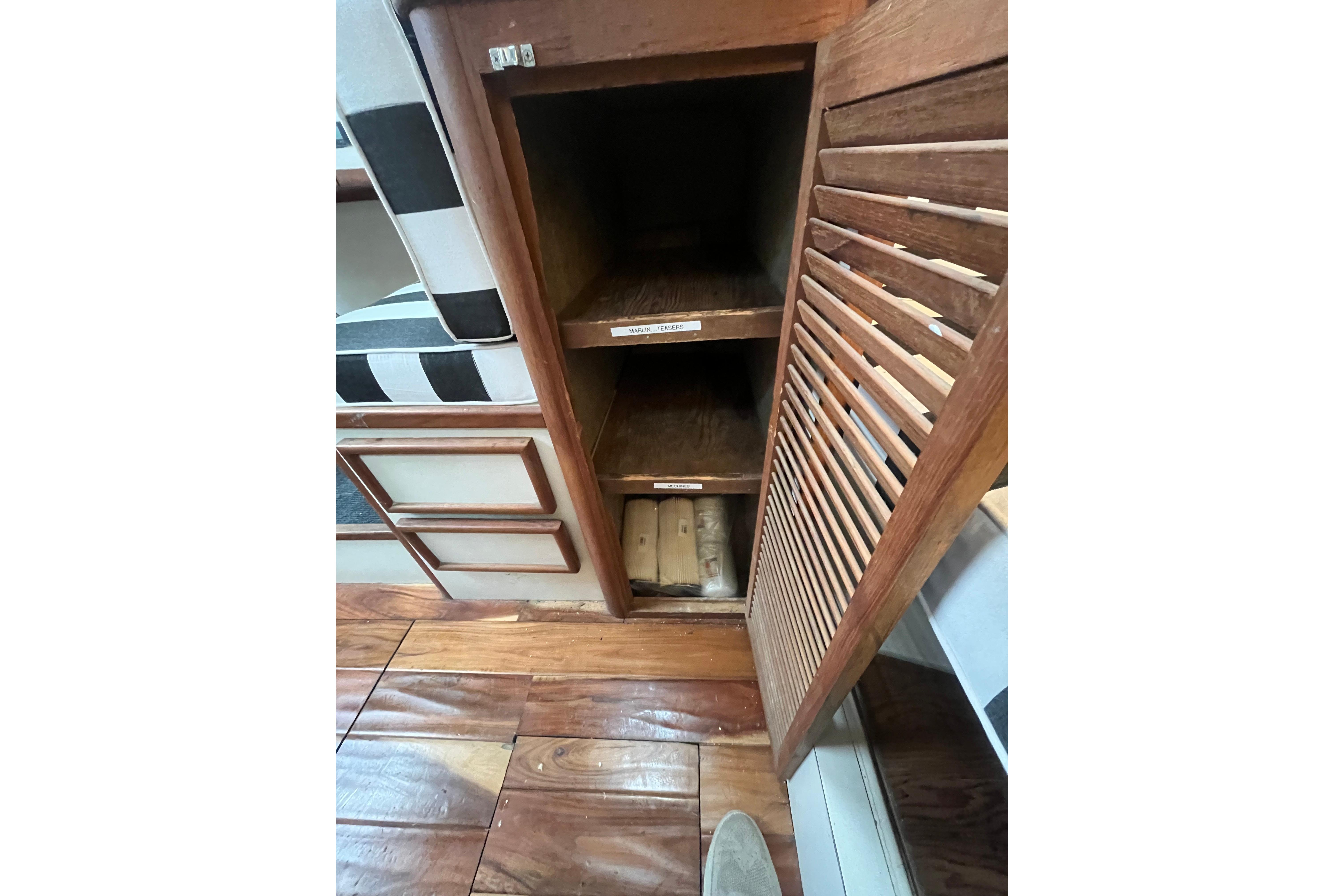 1989 Blackfin 31 Combi interior with wooden storage shelves and striped seating.