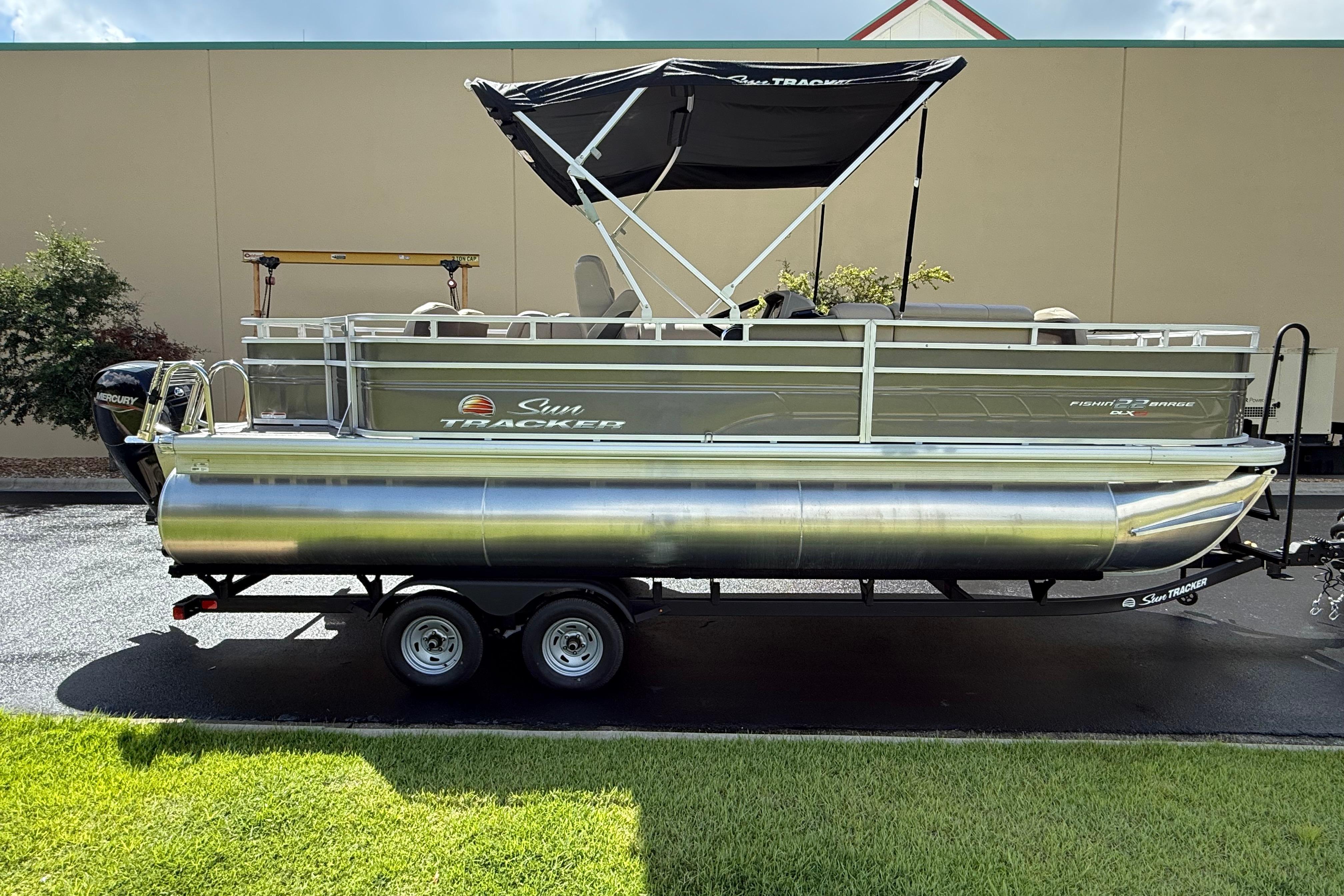2025 Sun Tracker Fishin' Barge 22 XP3 pontoon boat on trailer, side view.