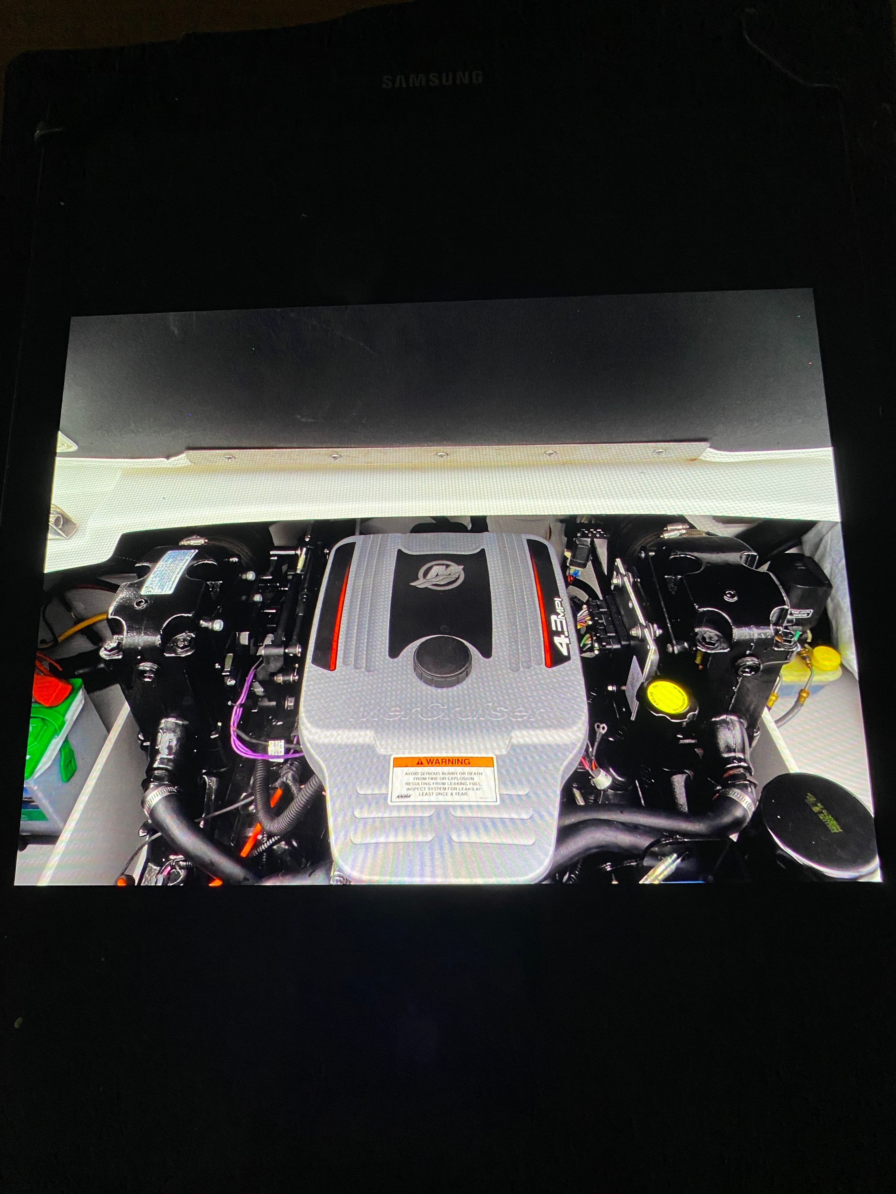 Engine compartment of a boat with a large engine in the center.