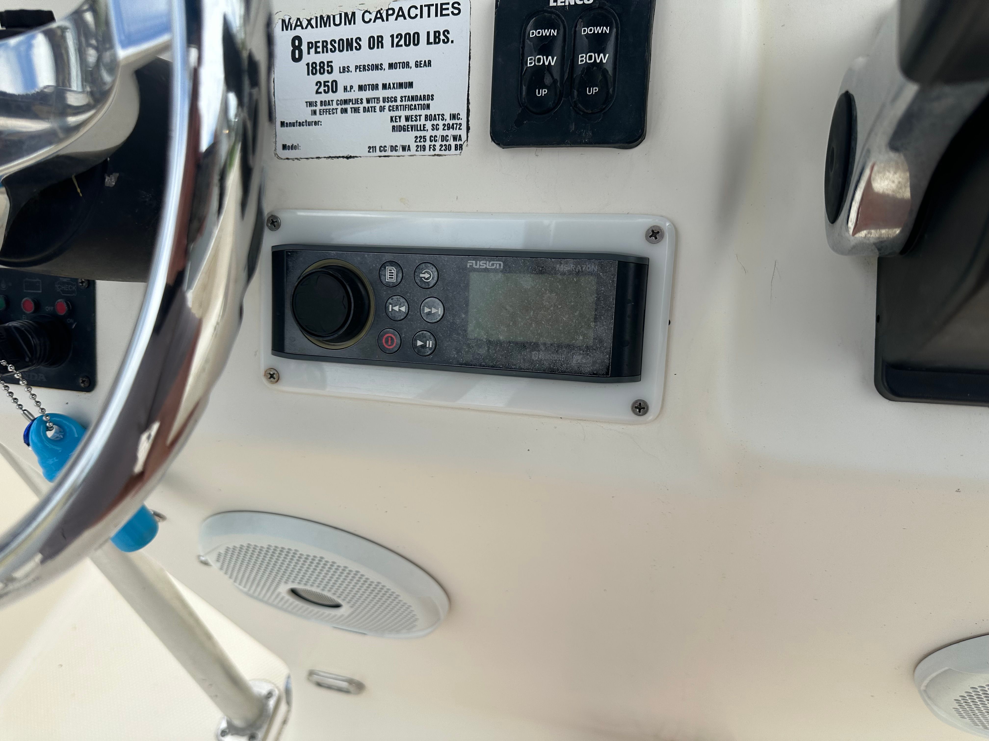 Close-up of a boat's helm with controls and speakers.