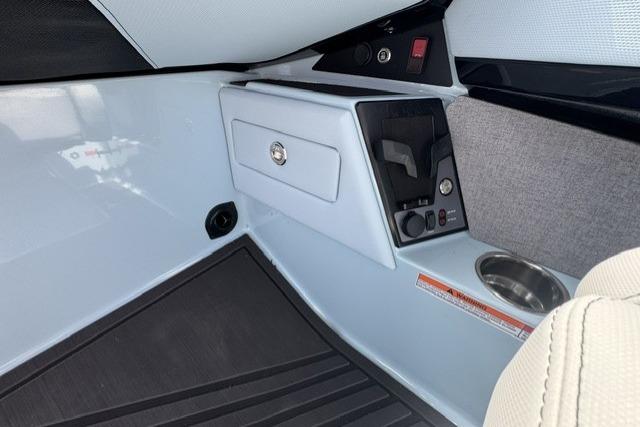 Interior of 2026 MasterCraft XStar 25 boat, featuring control panel and storage compartment.